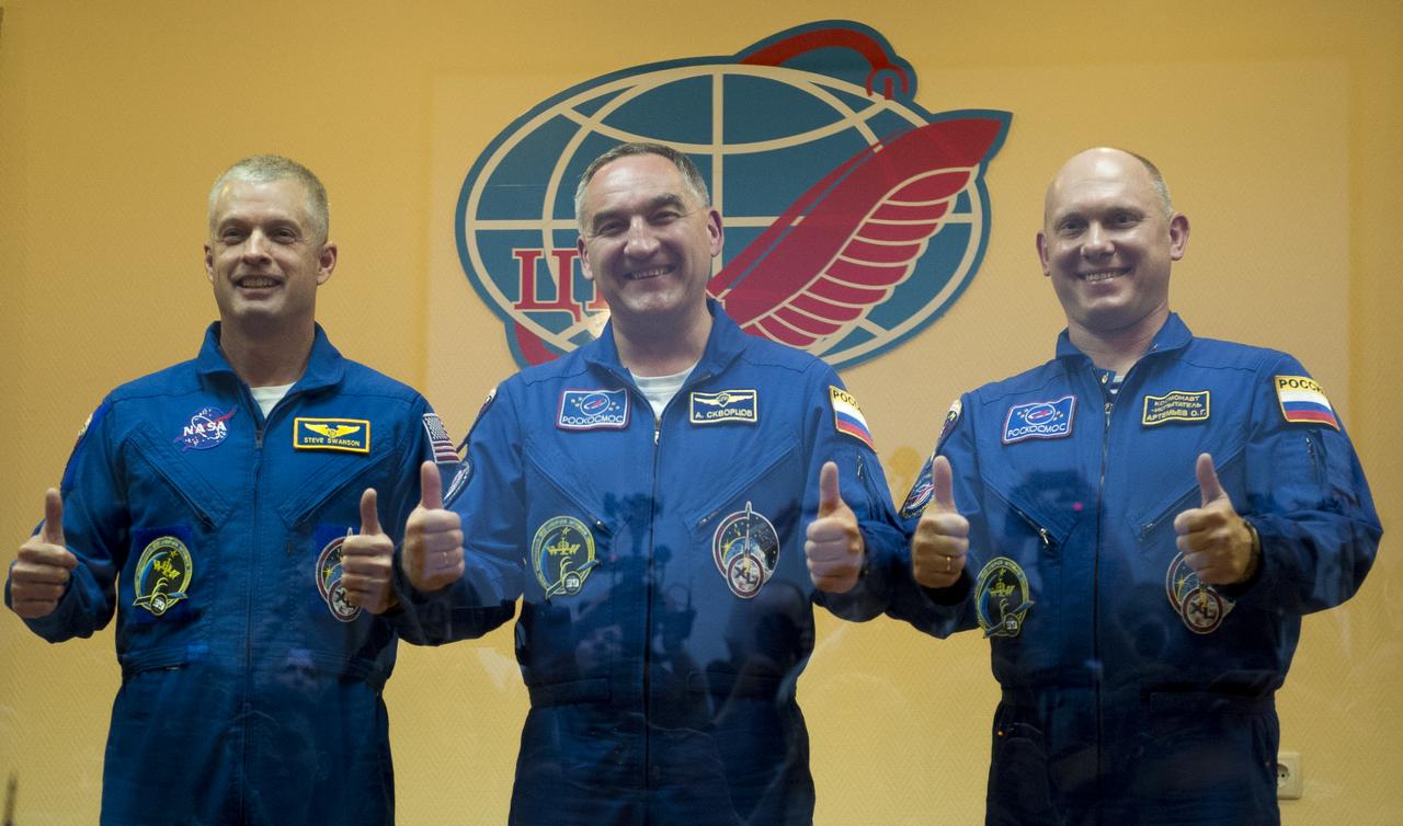 Expedition 39 primary crew flight engineer Steve Swanson of NASA, Soyuz commander Aleksander Skvortsov of the Russian Federal Space Agency, Roscosmos, flight engineer Oleg Artemyev of Roscosmos are seen in quarantine, behind glass, during the final press conference be Monday, March 24, 2014, at the Cosmonaut Hotel in Baikonur, Kazakhstan. The mission to the International Space Station is set to launch March 26 from the Baikonur Cosmodrome. Photo Credit: (NASA/Joel Kowsky)