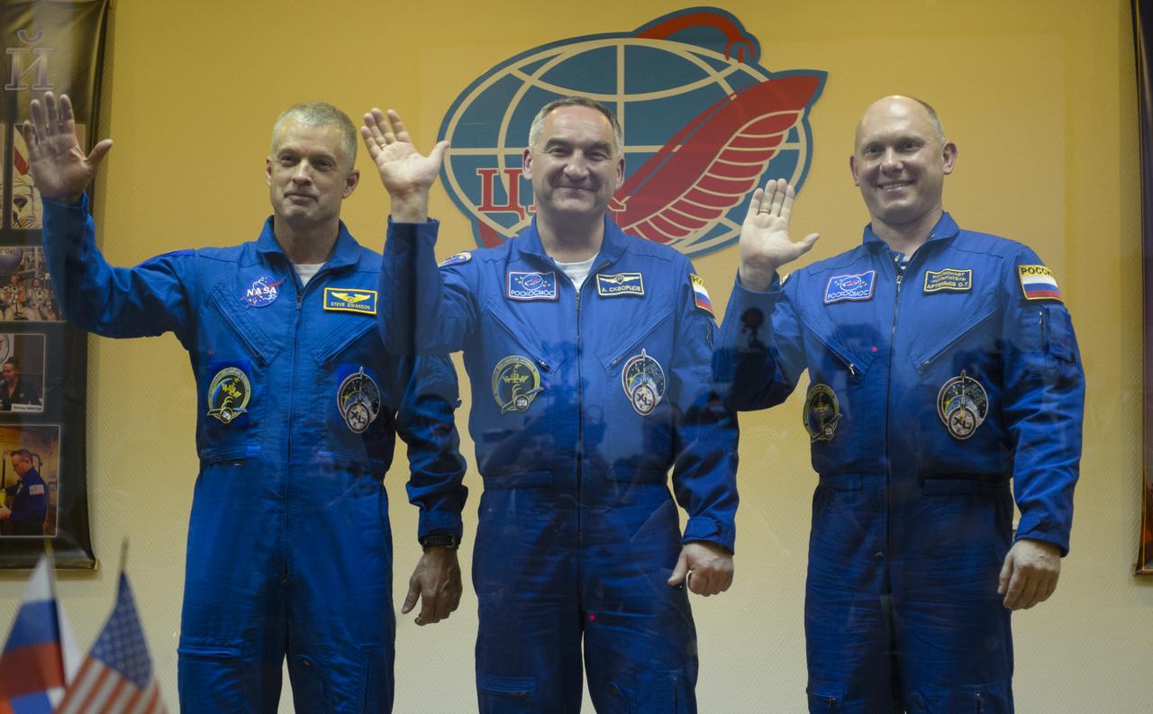 Expedition 39 primary crew flight engineer Steve Swanson of NASA, Soyuz commander Aleksander Skvortsov of the Russian Federal Space Agency, Roscosmos, flight engineer Oleg Artemyev of Roscosmos are seen in quarantine, behind glass, during the final press conference be Monday, March 24, 2014, at the Cosmonaut Hotel in Baikonur, Kazakhstan. The mission to the International Space Station is set to launch March 26 from the Baikonur Cosmodrome. Photo Credit: (NASA/Joel Kowsky)