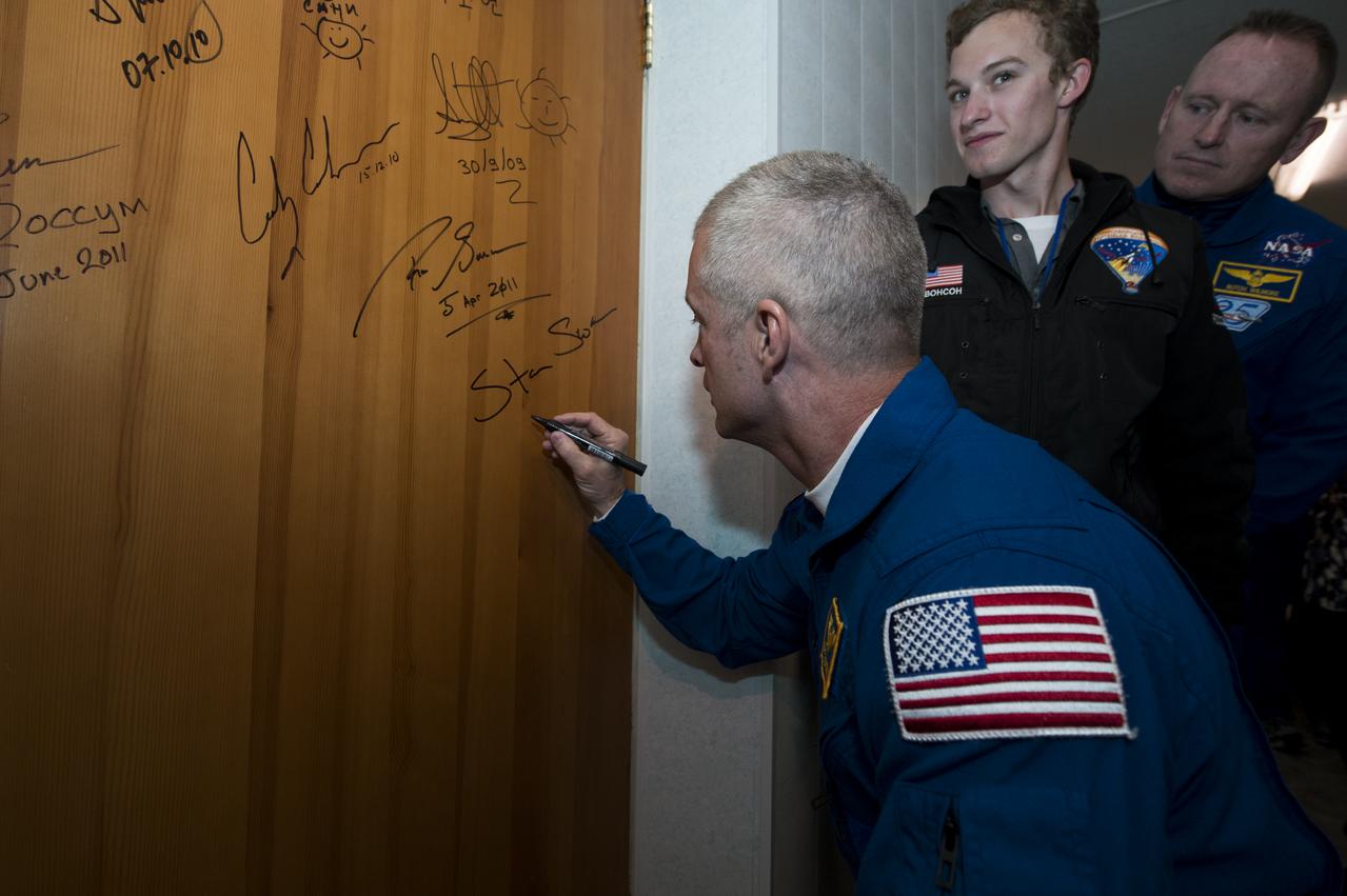 Expedition 39 Flight Engineer Steve Swanson of NASA, performs the traditional door signing at the Cosmonaut hotel prior to departing the hotel for launch in a Soyuz rocket with fellow crew mates, Soyuz Commander Alexander Skvortsov of the Russian Federal Space Agency, Roscosmos, and Flight Engineer Oleg Artemyev of Roscosmos, Tuesday, March 25, 2014, in Baikonur, Kazakhstan. Swanson, Skvortsov and, and Artemyev will launch in their Soyuz TMA-12M spacecraft to the International Space Station to begin a six-month mission. Photo Credit (NASA/Joel Kowsky)