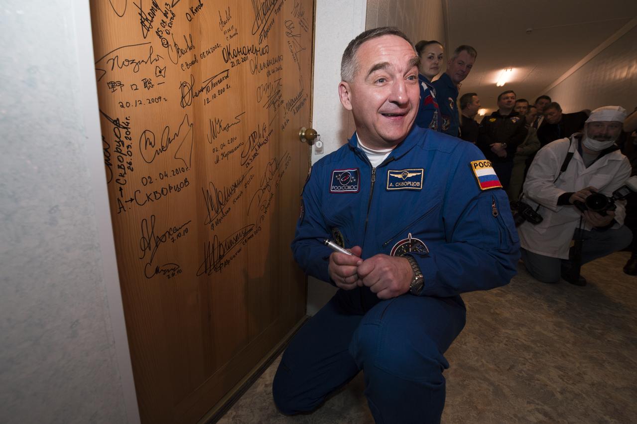 Expedition 39 Soyuz Commander Alexander Skvortsov of the Russian Federal Space Agency, Roscosmos, performs the traditional door signing at the Cosmonaut hotel prior to departing the hotel for launch in a Soyuz rocket with fellow crew mates, Flight Engineer Steve Swanson of NASA and Flight Engineer Oleg Artemyev of Roscosmos, Tuesday, March 25, 2014, in Baikonur, Kazakhstan. Skvortsov, Swanson, and Artemyev will launch in their Soyuz TMA-12M spacecraft to the International Space Station to begin a six-month mission. Photo Credit (NASA/Joel Kowsky)