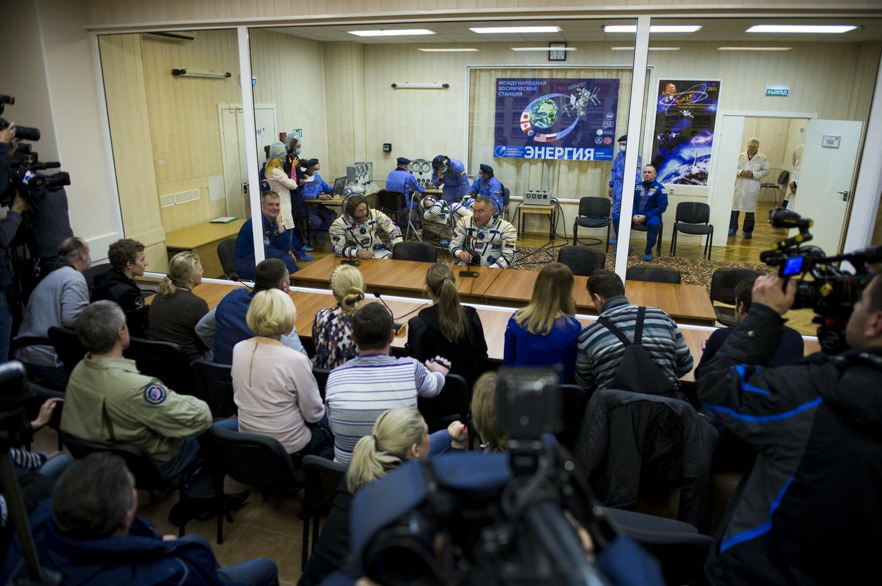Expedition 39 Flight Engineer Steve Swanson of NASA, left, and Soyuz Commander Alexander Skvortsov of the Russian Federal Space Agency, Roscosmos, right, speak with family members while Flight Engineer Oleg Artemyev of Roscosmos, has his Russian Sokol suit pressure checked in preparation for his launch onboard the Soyuz TMA-12M spacecraft on Tuesday, March 25, 2014 at the Baikonur Cosmodrome in Kazakhstan. The Soyuz spacecraft with Artemyev, Expedition 39 Soyuz Commander Alexander Skvortsov of Roscosmos and Flight Engineer Steve Swanson of NASA is scheduled to launch at 3:17 a.m. Kazakhstan time on Wednesday, March 26.