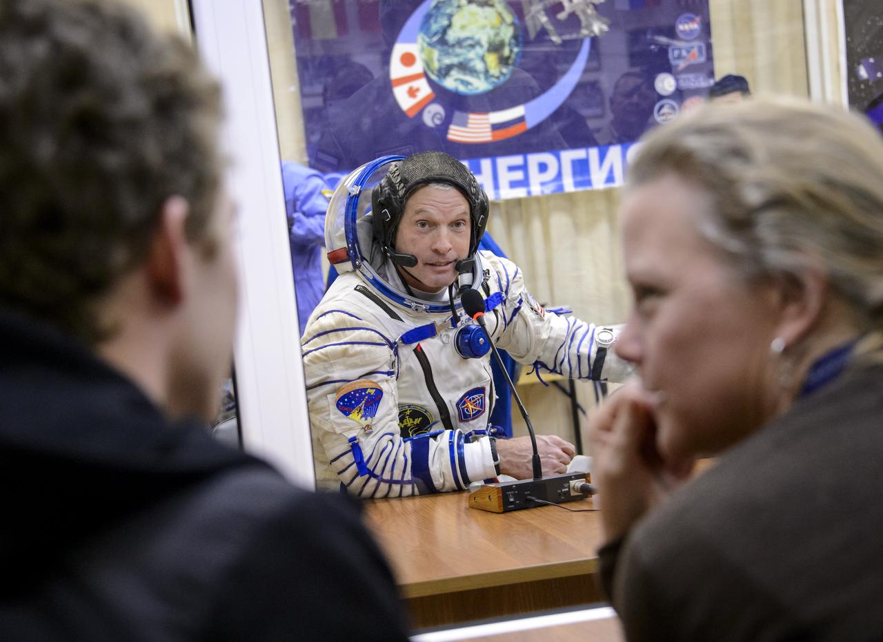 Expedition 39 Flight Engineer Steve Swanson of NASA speaks with his family during Russian Sokol suit pressure checks in preparation for launch onboard the Soyuz TMA-12M spacecraft on Tuesday, March 25, 2014 at the Baikonur Cosmodrome in Kazakhstan. The Soyuz spacecraft with Swanson, Expedition 39 Soyuz Commander Alexander Skvortsov of the Russian Federal Space Agency, Roscosmos, and Flight Engineer Oleg Artemyev of Roscosmos is scheduled to launch at 3:17 a.m. Kazakhstan time on Wednesday, March 26. (NASA/Bill Ingalls)