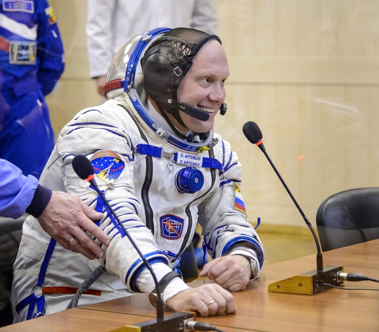 Expedition 39 Flight Engineer Oleg Artemyev of the Russian Federal Space Agency, Roscosmos, speaks with his family during Russian Sokol suit pressure checks in preparation for launch onboard the Soyuz TMA-12M spacecraft on Tuesday, March 25, 2014 at the Baikonur Cosmodrome in Kazakhstan. The Soyuz spacecraft with Artemyev, Expedition 39 Soyuz Commander Alexander Skvortsov of Roscosmos and Flight Engineer Steve Swanson of NASA is scheduled to launch at 3:17 a.m. Kazakhstan time on Wednesday, March 26. (NASA/Bill Ingalls)