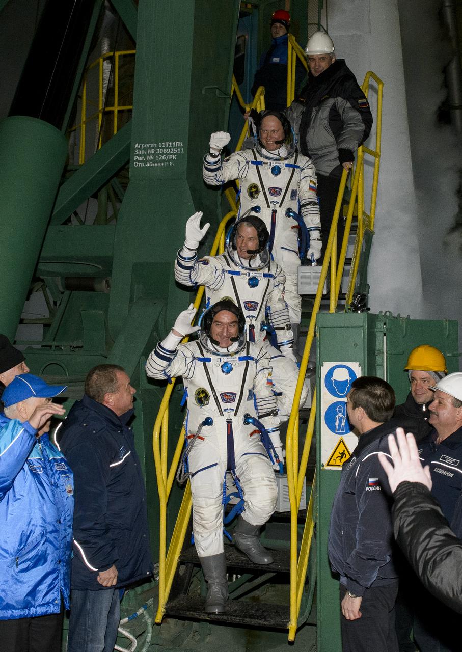 Expedition 39 Soyuz Commander Alexander Skvortsov of the Russian Federal Space Agency, Roscosmos, bottom, Flight Engineer Steve Swanson of NASA, middle, and Flight Engineer Oleg Artemyev of Roscosmos, wave farewell prior to boarding the Soyuz TMA-12M rocket for launch, Wednesday, March 26, 2014 at the Baikonur Cosmodrome in Kazakhstan. Skvortsov, Swanson, and Artemyev will spend the next six months aboard the International Space Station. Photo Credit: (NASA/Joel Kowsky)