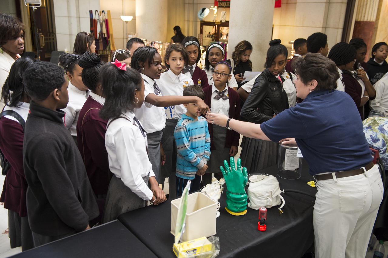 Students listen intently while an exhibitor conducts an experiment at NASA's Earth Day event. The event took place at Union Station in Washington, DC on April 22, 2014. Photo Credit: (NASA/Aubrey Gemignani)