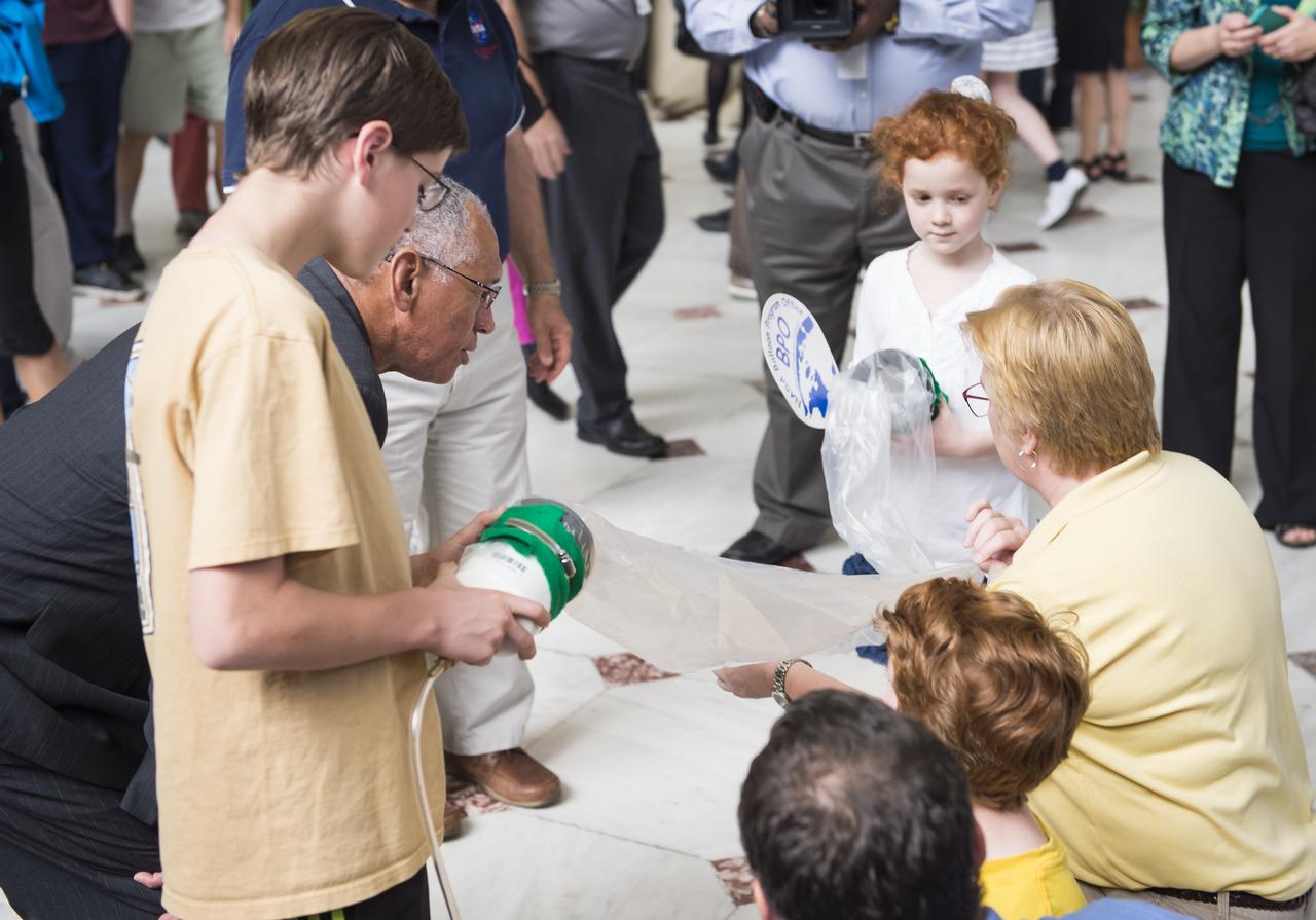 NASA's Administrator, Charles Bolden watches as some students conduct an experiment with a balloon at NASA's Earth Day event. The event took place at Union Station in Washington, DC on April 22, 2014. Photo Credit: (NASA/Aubrey Gemignani)