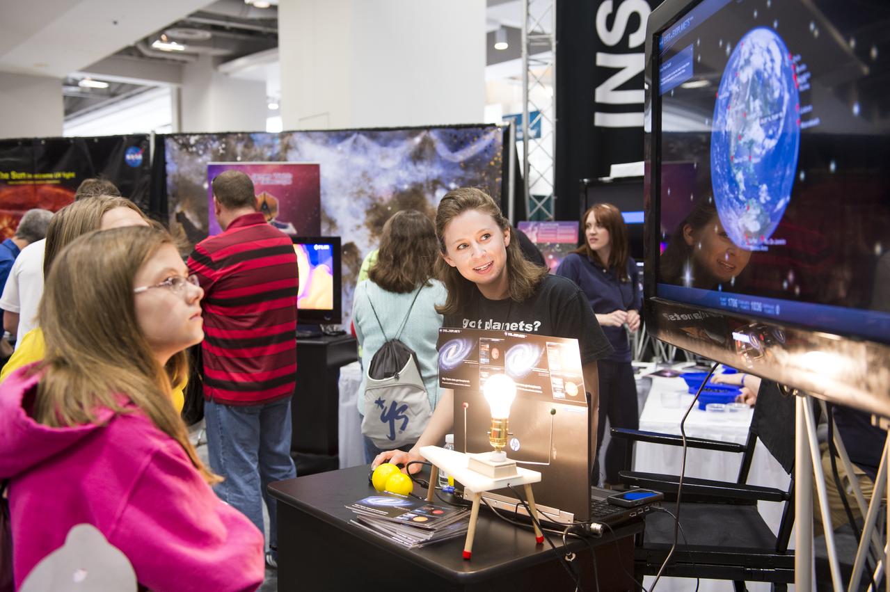 A NASA staff member discusses planets with attendees of the USA Science and Engineering Festival, which took place at the Washington Convention Center in Washington, DC on April 26 and 27, 2014. Photo Credit: (NASA/Aubrey Gemignani)