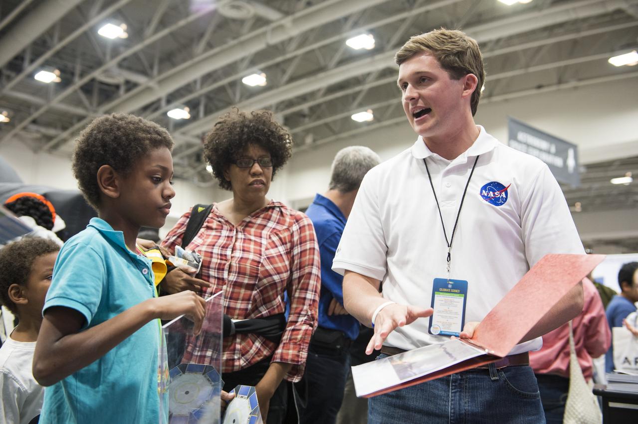 An attendee of the USA Science and Engineering Festival observes the infrared image of himself as a NASA staff member describes the James Webb Space Telescope. It will be a large infrared telescope with a 6.5 meter primary mirror and will study every phase in the history of our Universe ranging from the Big Bang to the formation of our Solar System. The USA Science and Engineering Festival took place at the Washington Convention Center in Washington, DC on April 26 and 27, 2014. Photo Credit: (NASA/Aubrey Gemignani)