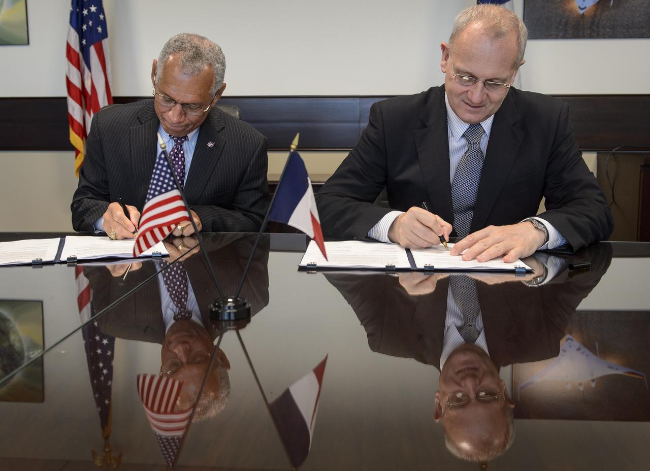 NASA Administrator Charles Bolden, left, and Centre National d'Études Spatiales (CNES) President Jean-Yves Le Gall sign an agreement to move from feasibility studies to implementation of the Surface Water and Ocean Topography (SWOT) mission, Friday, May 2, 2014 at NASA Headquarters in Washington. The SWOT mission will use wide swath altimetry technology to produce high-resolution elevation measurements of the surface of lakes, reservoirs, and wetlands and of the ocean surface. Photo Credit: (NASA/Bill Ingalls)