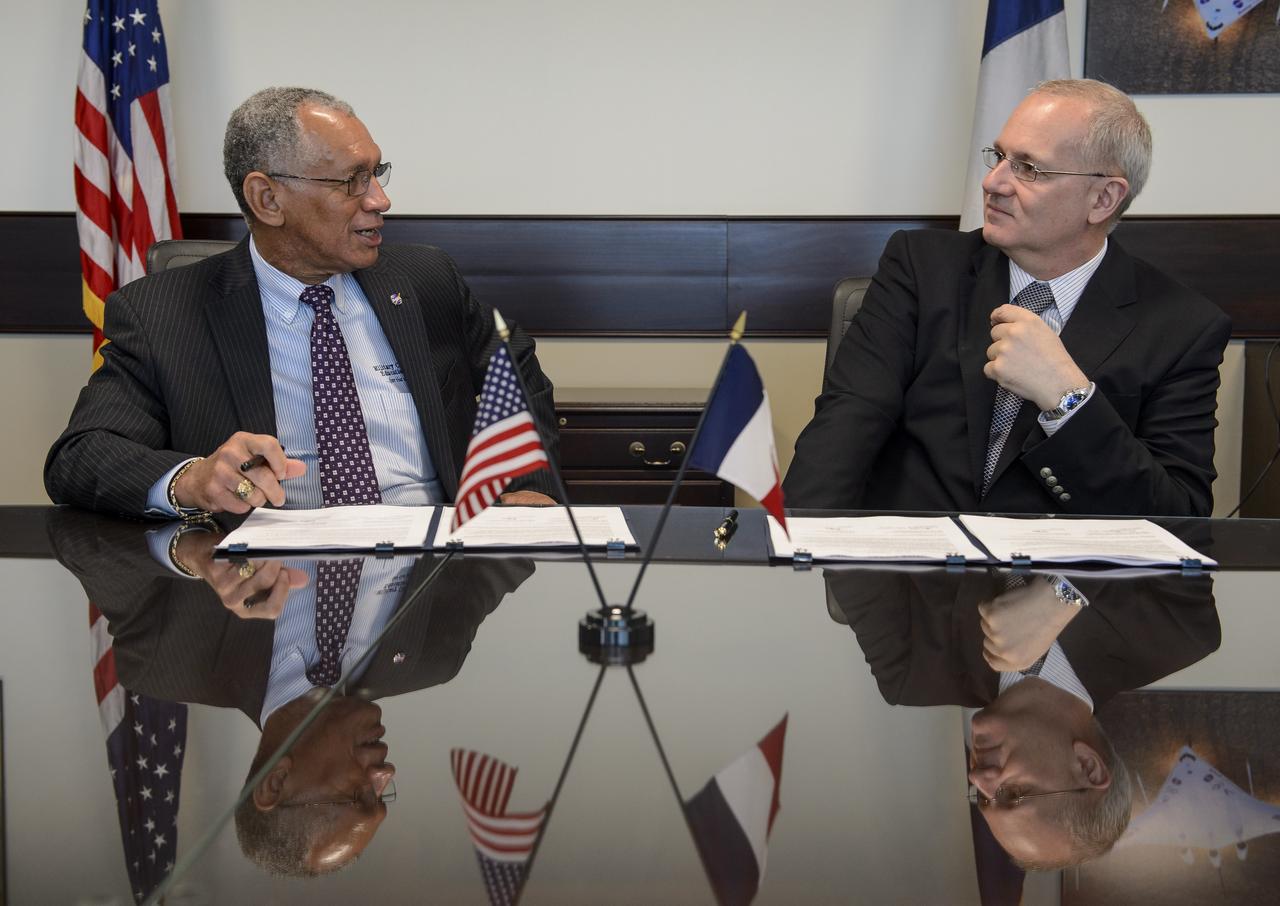 NASA Administrator Charles Bolden, left, and Centre National d'Études Spatiales (CNES) President Jean-Yves Le Gall talk after signing an agreement to move from feasibility studies to implementation of the Surface Water and Ocean Topography (SWOT) mission, Friday, May 2, 2014 at NASA Headquarters in Washington. The SWOT mission will use wide swath altimetry technology to produce high-resolution elevation measurements of the surface of lakes, reservoirs, and wetlands and of the ocean surface. Photo Credit: (NASA/Bill Ingalls)