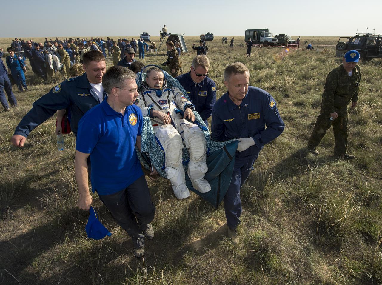 Soyuz Commander Mikhail Tyurin of Roscosmos is carried in a chair to a medical tent just minutes after he and Expedition 39 Commander Koichi Wakata of the Japan Aerospace Exploration Agency (JAXA), and Flight Engineer Rick Mastracchio of NASA, landed in their Soyuz TMA-11M spacecraft near the town of Zhezkazgan, Kazakhstan on Wednesday, May 14, 2014. Wakata, Tyurin and Mastracchio returned to Earth after more than six months onboard the International Space Station where they served as members of the Expedition 38 and 39 crews. Photo Credit: (NASA/Bill Ingalls)