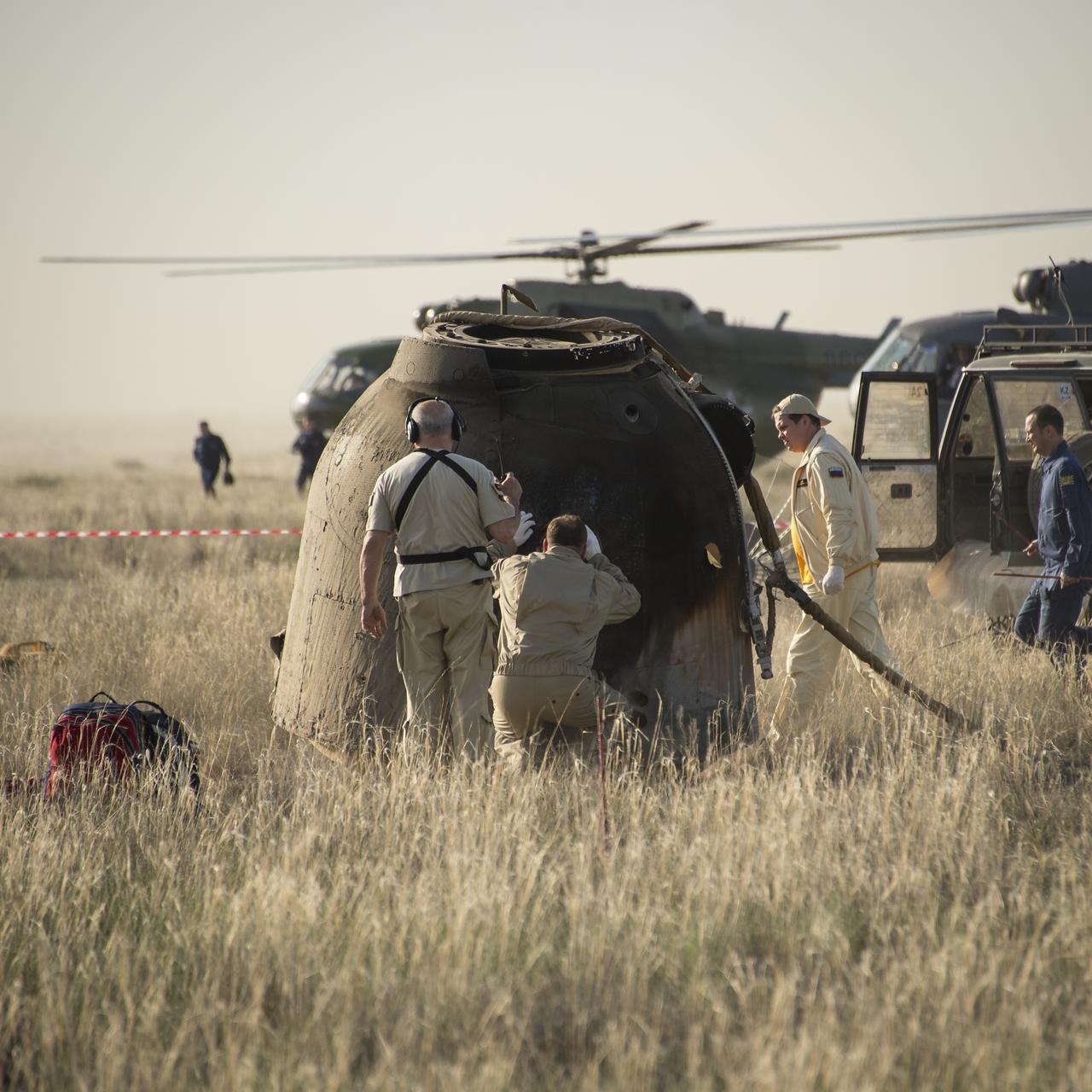 Support personnel prepare to exact the crew from the Soyuz TMA-11M spacecraft shortly after it landed with Expedition 39 Commander Koichi Wakata of the Japan Aerospace Exploration Agency (JAXA), Soyuz Commander Mikhail Tyurin of Roscosmos, and Flight Engineer Rick Mastracchio of NASA near the town of Zhezkazgan, Kazakhstan on Wednesday, May 14, 2014. Wakata, Tyurin and Mastracchio returned to Earth after more than six months onboard the International Space Station where they served as members of the Expedition 38 and 39 crews. Photo Credit: (NASA/Bill Ingalls)