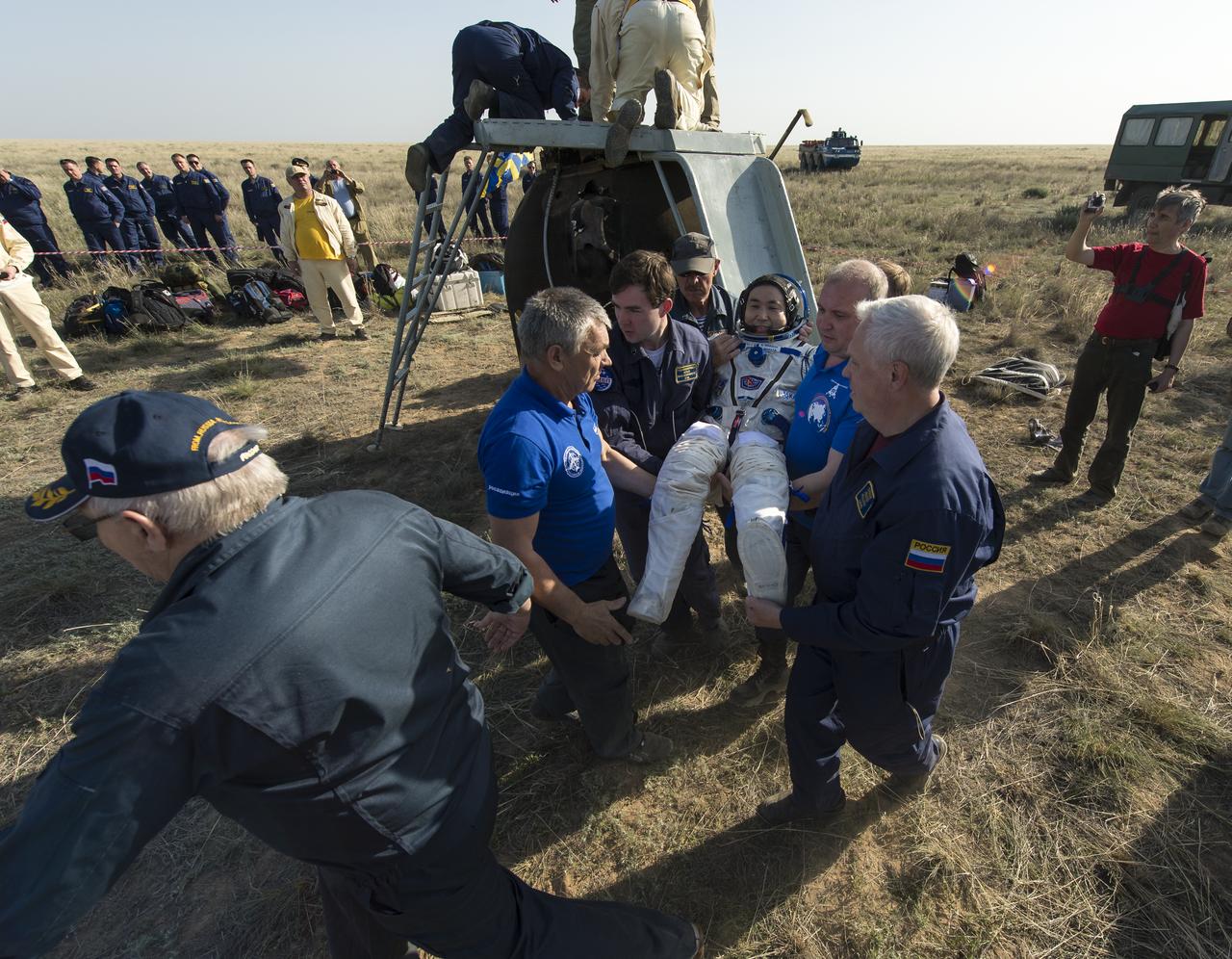 Expedition 39 Commander Koichi Wakata of the Japan Aerospace Exploration Agency (JAXA) is helped of the Soyuz Capsule just minutes after he and Soyuz Commander Mikhail Tyurin of Roscosmos, and Flight Engineer Rick Mastracchio of NASA, landed in their Soyuz TMA-11M spacecraft near the town of Zhezkazgan, Kazakhstan on Wednesday, May 14, 2014. Wakata, Tyurin and Mastracchio returned to Earth after more than six months onboard the International Space Station where they served as members of the Expedition 38 and 39 crews. Photo Credit: (NASA/Bill Ingalls)