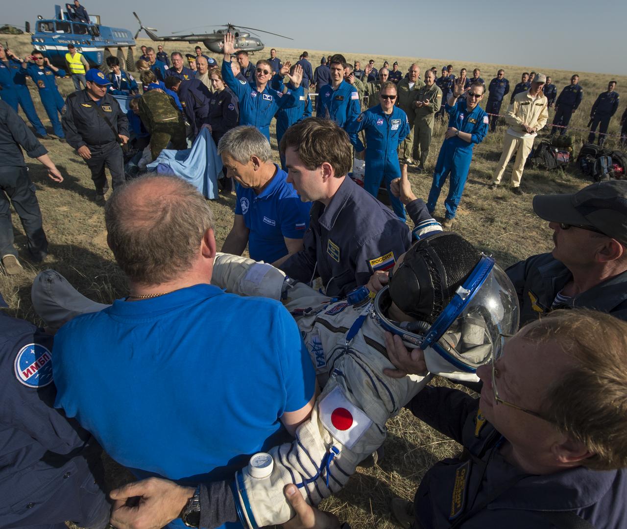 Expedition 39 Commander Koichi Wakata of the Japan Aerospace Exploration Agency (JAXA) gives a thumbs up to his NASA and Russian partners as he is carried from the Soyuz Capsule just minutes after he and Soyuz Commander Mikhail Tyurin of Roscosmos, and Flight Engineer Rick Mastracchio of NASA, landed in their Soyuz TMA-11M spacecraft near the town of Zhezkazgan, Kazakhstan on Wednesday, May 14, 2014. Wakata, Tyurin and Mastracchio returned to Earth after more than six months onboard the International Space Station where they served as members of the Expedition 38 and 39 crews. Photo Credit: (NASA/Bill Ingalls)