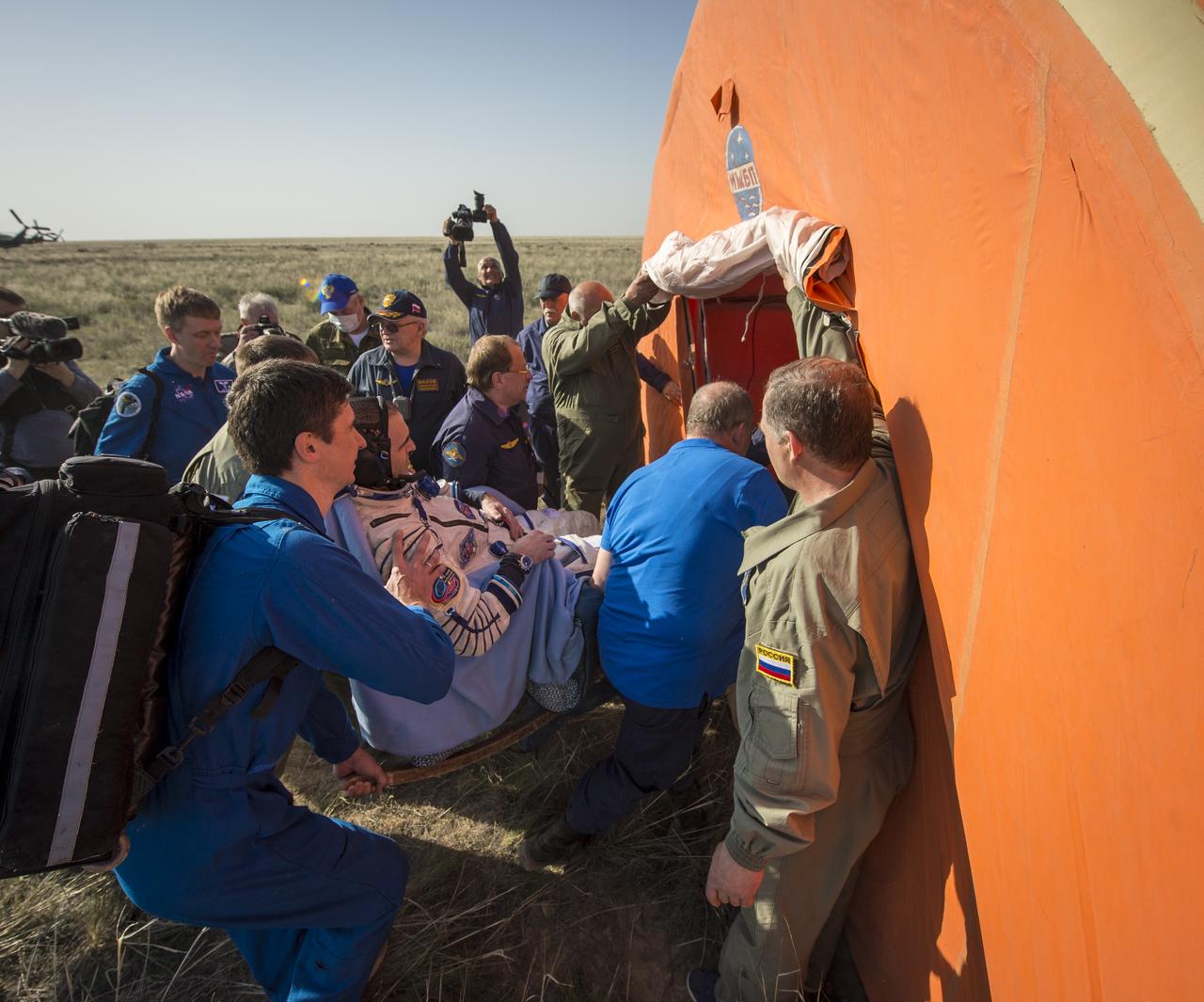 Expedition 39 Flight Engineer Rick Mastracchio of NASA is carried in a chair to a medical tent just minutes after he and Expedition 39 Commander Koichi Wakata of the Japan Aerospace Exploration Agency (JAXA), and Soyuz Commander Mikhail Tyurin of Roscosmos landed in their Soyuz TMA-11M spacecraft near the town of Zhezkazgan, Kazakhstan on Wednesday, May 14, 2014. Wakata, Tyurin and Mastracchio returned to Earth after more than six months onboard the International Space Station where they served as members of the Expedition 38 and 39 crews. Photo Credit: (NASA/Bill Ingalls)