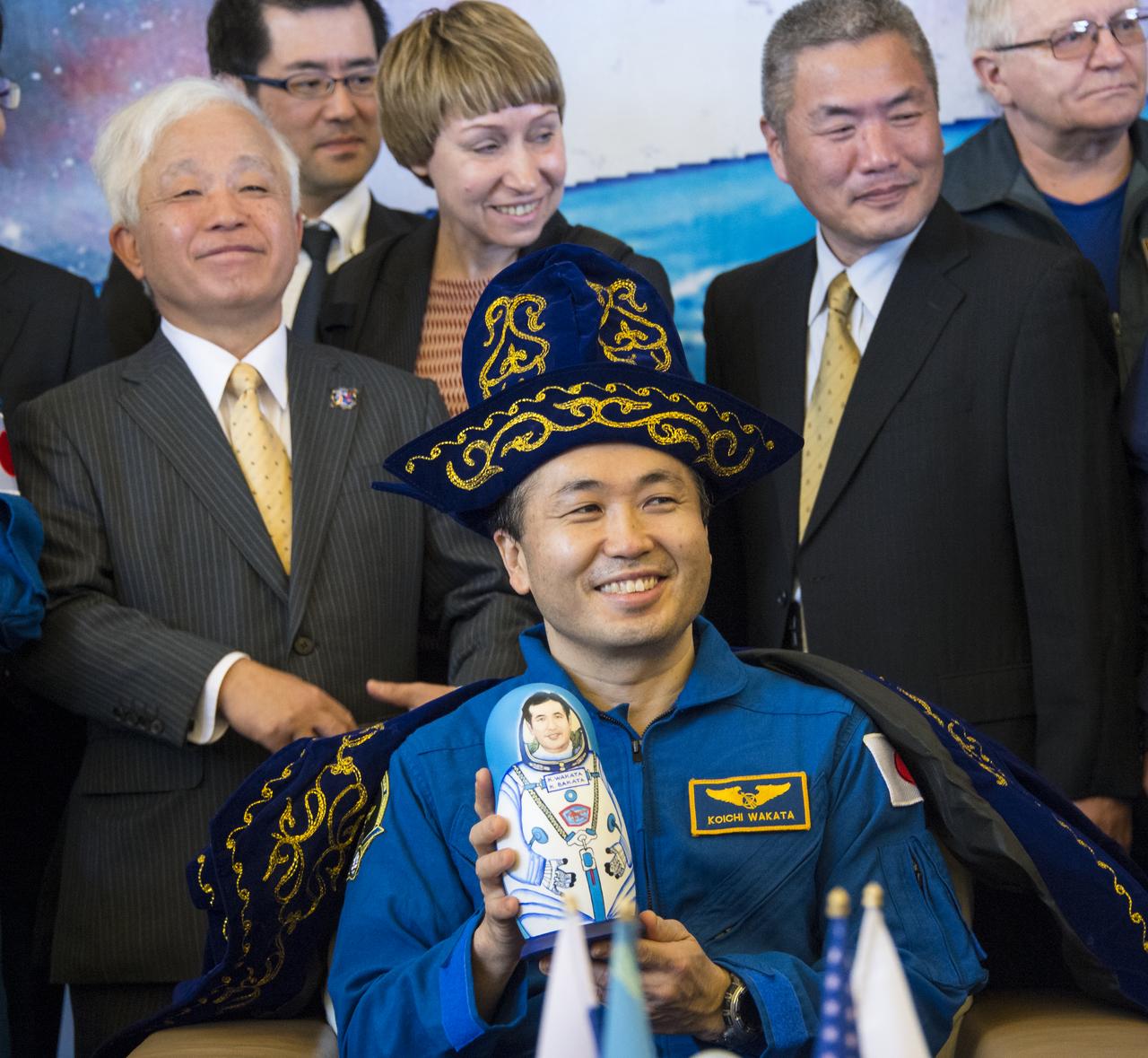 Expedition 39 Commander Koichi Wakata of the Japan Aerospace Exploration Agency (JAXA) is seen wearing a ceremonial Kazakh hat and robe and holding a matryoshka doll presented to him during a welcome home ceremony, Wednesday, May 14, 2014 at the Karaganda Airport in Kazakhstan. Wakata, Expedition 39 Soyuz Commander Mikhail Tyurin of Roscosmos, and Flight Engineer Rick Mastracchio of NASA landed in their Soyuz TMA-11M spacecraft just a few hours earlier near the town of Zhezkazgan. Wakata, Tyurin and Mastracchio returned to Earth after more than six months onboard the International Space Station where they served as members of the Expedition 38 and 39 crews. Photo Credit: (NASA/Bill Ingalls)