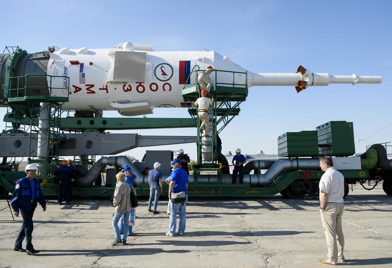 Workers prepare the Soyuz rocket to be raised into the vertical position for launch  on Monday, May 26, 2014, at the Baikonur Cosmodrome in Kazakhstan.  Launch of the Soyuz rocket is scheduled for May 29 and will send Expedition 40 Soyuz Commander Maxim Suraev, of the Russian Federal Space Agency, Roscosmos, Flight Engineer Alexander Gerst, of the European Space Agency, ESA, and Flight Engineer Reid Wiseman of NASA on a five and a half month mission aboard the International Space Station.  Photo Credit: (NASA/Joel Kowsky)