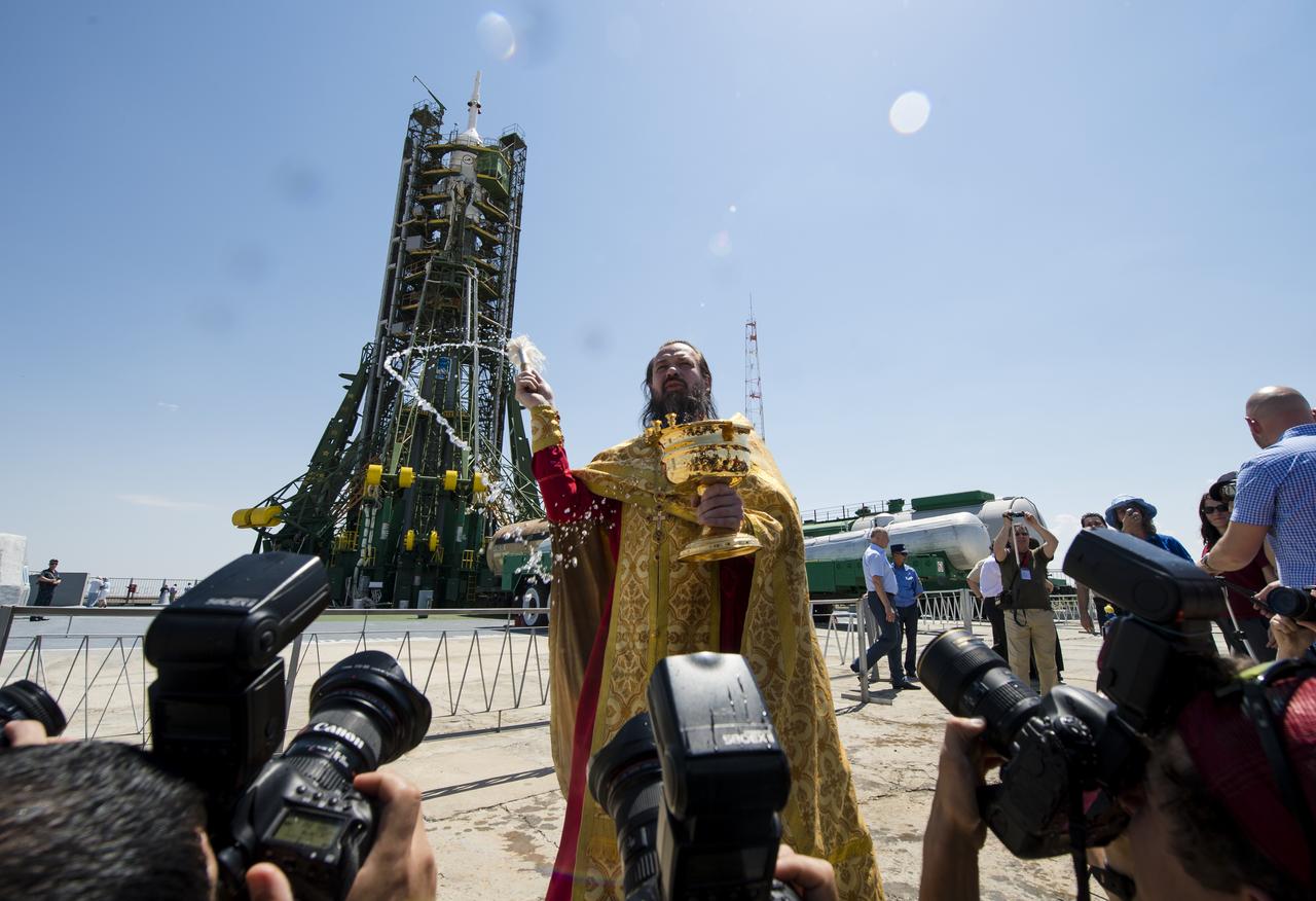 An Orthodox priest blesses members of the media at the Baikonur Cosmodrome launch pad on Tuesday, May 27, 2014 in Kazakhstan.  Launch of the Soyuz rocket is scheduled for May 29 and will send Expedition 40 Soyuz Commander Maxim Suraev, of the Russian Federal Space Agency, Roscosmos, Flight Engineer Alexander Gerst, of the European Space Agency, ESA, and Flight Engineer Reid Wiseman of NASA on a five and a half month mission aboard the International Space Station.  Photo Credit: (NASA/Joel Kowsky)