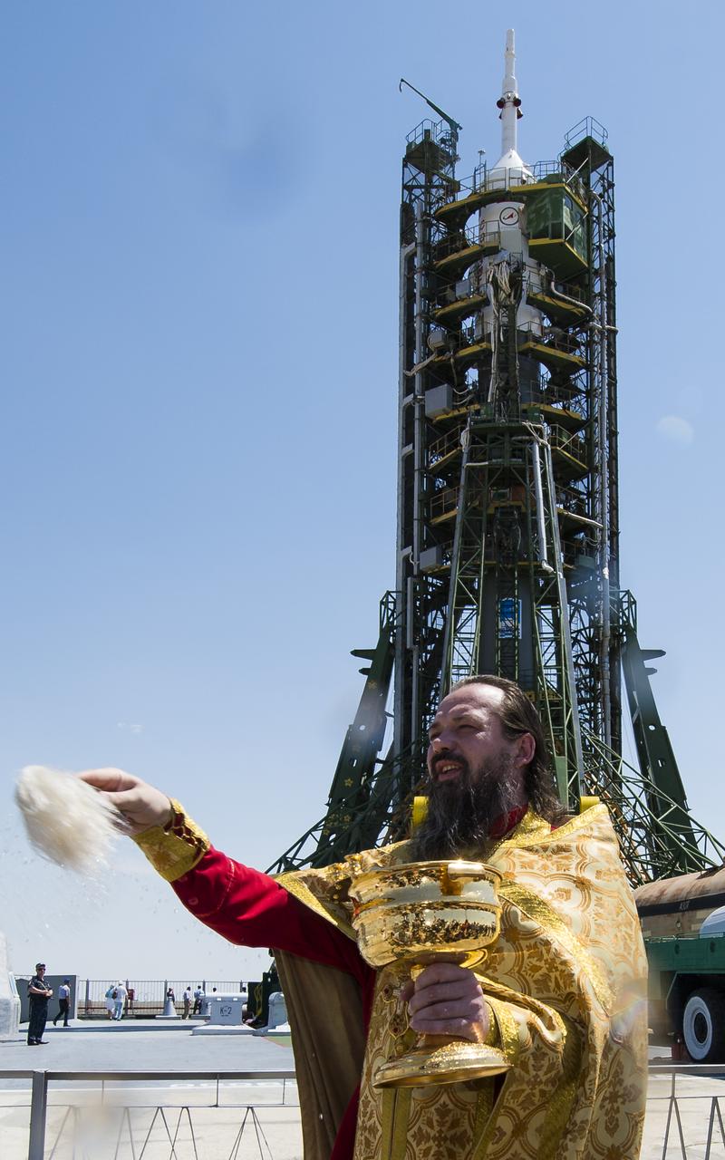 An Orthodox priest blesses members of the media at the Baikonur Cosmodrome launch pad on Tuesday, May 27, 2014 in Kazakhstan.  Launch of the Soyuz rocket is scheduled for May 29 and will send Expedition 40 Soyuz Commander Maxim Suraev, of the Russian Federal Space Agency, Roscosmos, Flight Engineer Alexander Gerst, of the European Space Agency, ESA, and Flight Engineer Reid Wiseman of NASA on a five and a half month mission aboard the International Space Station.  Photo Credit: (NASA/Joel Kowsky)