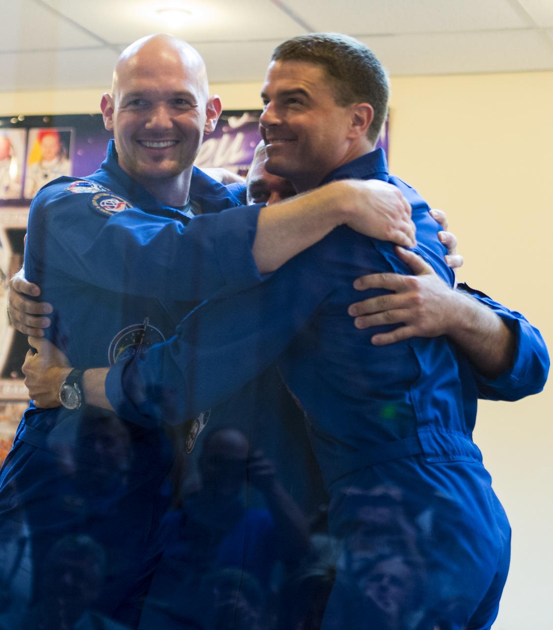 Expedition 40 Flight Engineer Alexander Gerst of the European Space Agency, ESA, left, Soyuz Commander Maxim Suraev of the Russian Federal Space Agency, Roscosmos, center, and Flight Engineer Reid Wiseman of NASA, left, hug each other during a press conference, Tuesday, May 27, 2014, at the Cosmonaut Hotel in Baikonur, Kazakhstan. The trio will launch aboard their Soyuz TMA-13M spacecraft on their mission to the International Space Station in the early hours of May 29. Photo Credit: (NASA/Joel Kowsky)