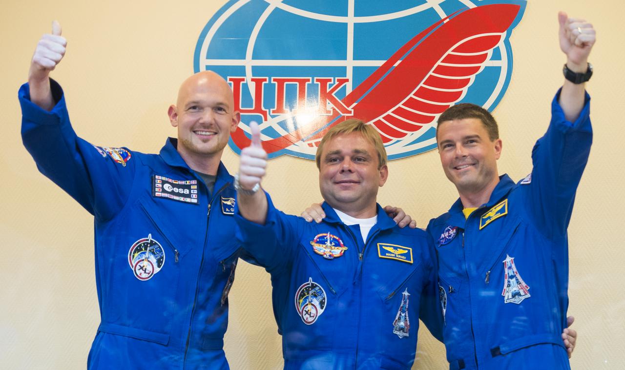 Expedition 40 Flight Engineer Alexander Gerst of the European Space Agency, ESA, left, Soyuz Commander Maxim Suraev of the Russian Federal Space Agency, Roscosmos, center, and Flight Engineer Reid Wiseman of NASA, right, pose for a picture at the conclusion of a press conference, Tuesday, May 27, 2014, at the Cosmonaut Hotel in Baikonur, Kazakhstan. The mission to the International Space Station is set to launch May 29 from the Baikonur Cosmodrome. Photo Credit: (NASA/Joel Kowsky)