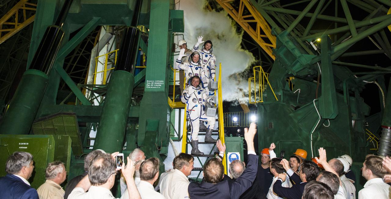 Expedition 40 Soyuz Commander Maxim Suraev of the Russian Federal Space Agency, Roscosmos, bottom, Flight Engineer Reid Wiseman of NASA, center, and Flight Engineer Alexander Gerst of the European Space Agency, ESA, top, wave farewell prior to boarding the Soyuz TMA-13M rocket for launch, Wednesday, May 28, 2014 at the Baikonur Cosmodrome in Kazakhstan. Suraev, Gerst, and Wiseman will spend the next six months aboard the International Space Station. Photo Credit: (NASA/Joel Kowsky)