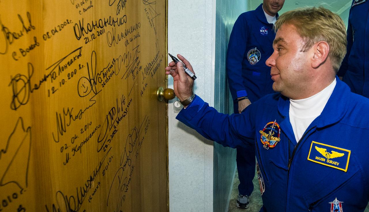 Expedition 40 Soyuz Commander Maxim Suraev of the Russian Federal Space Agency, Roscosmos, performs the traditional door signing at the Cosmonaut Hotel prior to departing the hotel for launch in a Soyuz rocket with fellow crew mates, Flight Engineer Alexander Gerst of the European Space Agency, ESA, and Flight Engineer Reid Wiseman of NASA, Wednesday, May 28, 2014 in Baikonur, Kazakhstan. Suraev, Gerst, and Wiseman will launch in their Soyuz TMA-13M spacecraft to the International Space Station to begin a five and a half month mission. Photo Credit (NASA/Joel Kowsky)