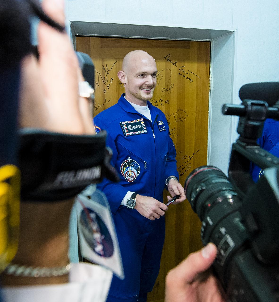 Expedition 40 Flight Engineer Alexander Gerst of the European Space Agency, ESA, performs the traditional door signing at the Cosmonaut Hotel prior to departing the hotel for launch in a Soyuz rocket with fellow crew mates, Soyuz Commander Maxim Suraev of the Russian Federal Space Agency, Roscosmos, and Flight Engineer Reid Wiseman of NASA, Wednesday, May 28, 2014, in Baikonur, Kazakhstan. Gerst, Suraev, and Wiseman will launch in their Soyuz TMA-13M spacecraft to the International Space Station to begin a five and a half month mission. Photo Credit (NASA/Joel Kowsky)