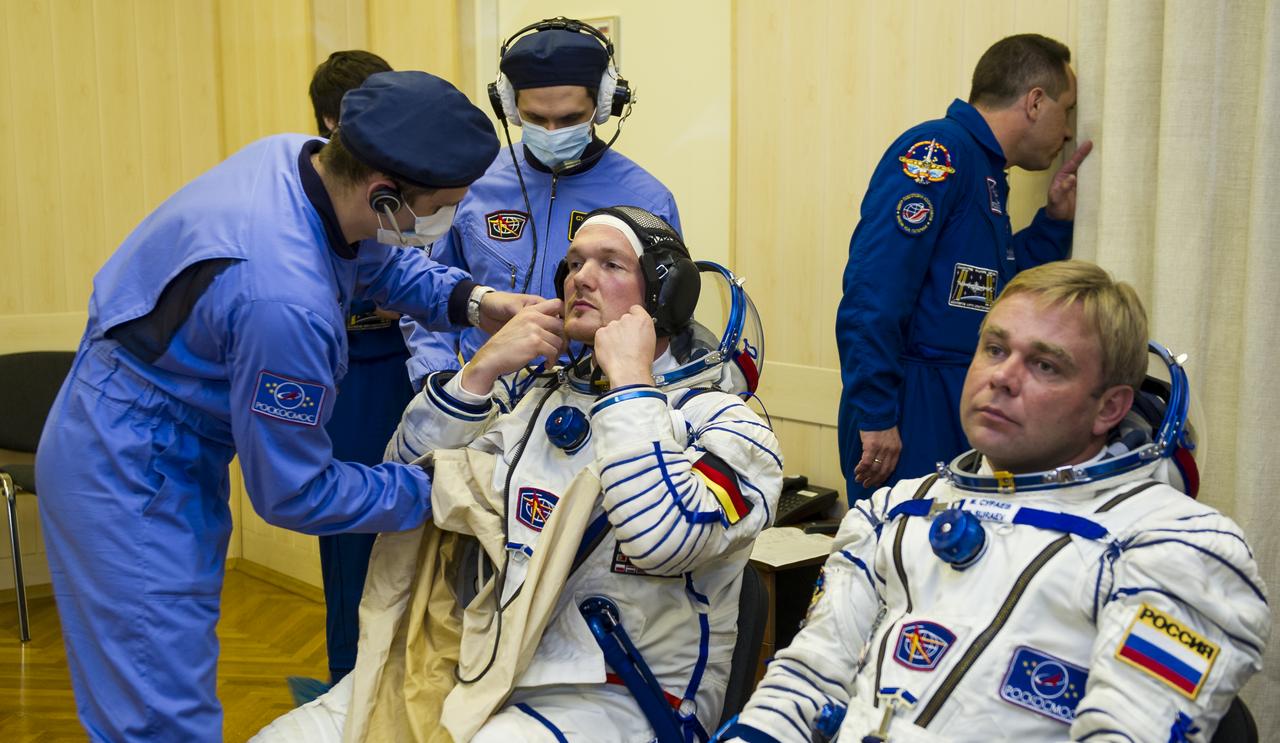 Expedition 40 Flight Engineer Alexander Gerst of the European Space Agency, ESA, is helped into his Russian Sokol suit as he and fellow cremates, Soyuz Commander Maxim Suraev of the Russian Federal Space Agency, Roscosmos, and Flight Engineer Reid Wiseman of NASA prepare for their Soyuz launch to the International Space Station, on Wednesday, May 28, 2014, in Baikonur, Kazakhstan. Launch of the Soyuz rocket will send Gerst, Suraev, and Wiseman on a five and a half month mission aboard the International Space Station. Photo Credit: (NASA/GCTC/Irina Peshkova)