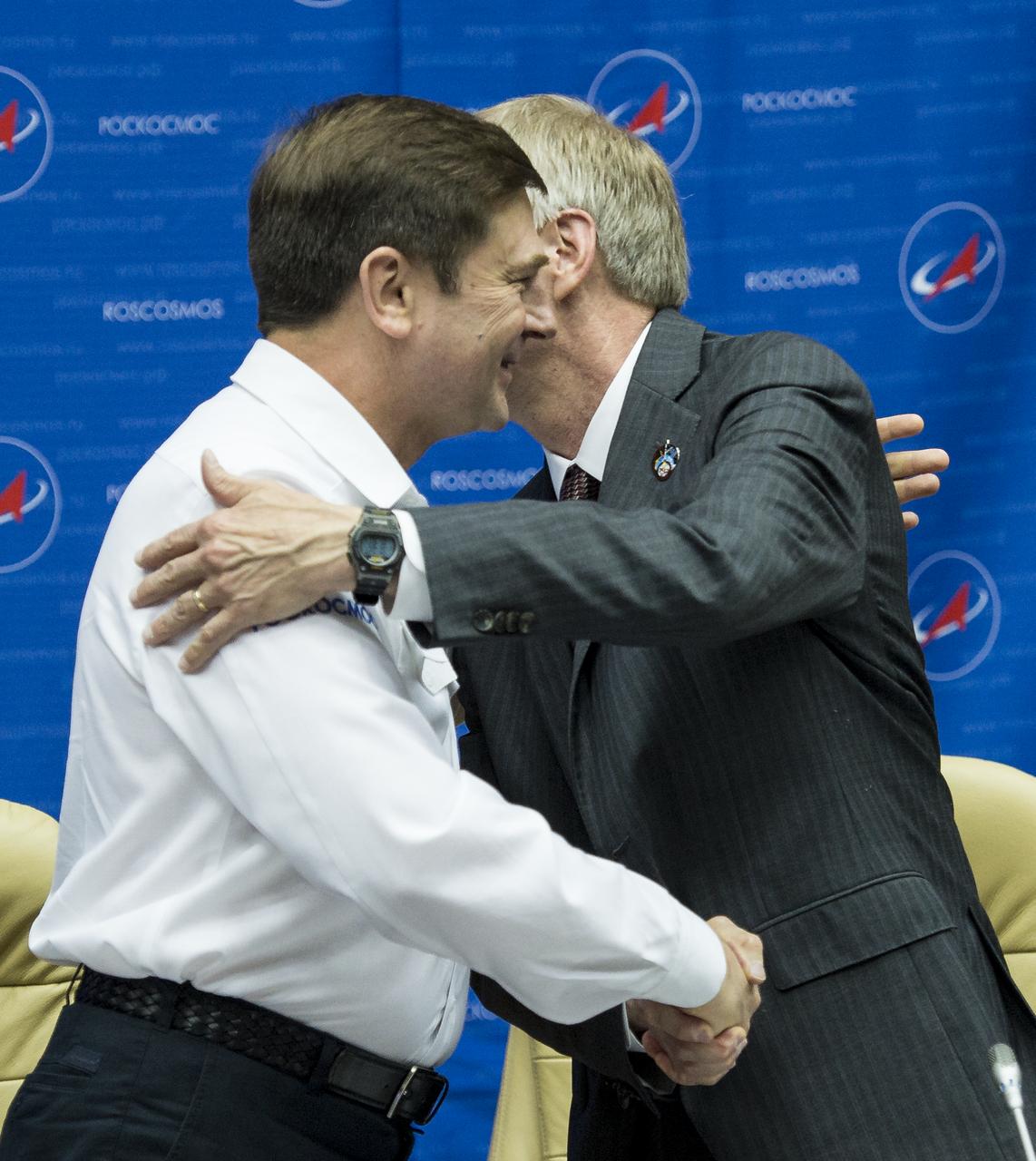 Oleg Ostapenko, General Director of the Russian Federal Space Agency, Roscosmos, left, and William Gerstenmaier, NASA Associate Administrator for Human Exploration and Operations, right, shake hands following a joint statement after the docking of the Soyuz TMA-13M spacecraft with the International Space Station on Thursday, May 29, 2014 at the Baikonur Hotel in Baikonur, Kazakhstan.  Photo Credit: (NASA/Joel Kowsky)