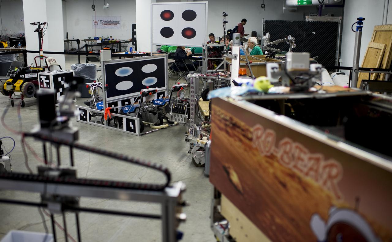 Robots that will be competing in the Level one competition are seen as they sit in impound prior to the start of competition at the 2014 NASA Centennial Challenges Sample Return Robot Challenge, Wednesday, June 11, 2014, at the Worcester Polytechnic Institute (WPI) in Worcester, Mass.   Eighteen teams competing for a $1.5 million NASA prize purse. Teams will be required to demonstrate autonomous robots that can locate and collect samples from a wide and varied terrain, operating without human control. The objective of this NASA-WPI Centennial Challenge is to encourage innovations in autonomous navigation and robotics technologies. Innovations stemming from the challenge may improve NASA's capability to explore a variety of destinations in space, as well as enhance the nation's robotic technology for use in industries and applications on Earth. Photo Credit: (NASA/Joel Kowsky)