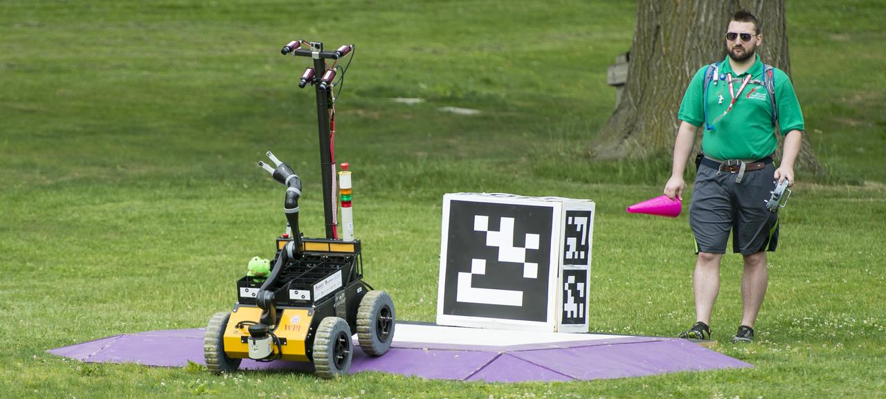 The team AERO robot drives off the starting platform during the level one competition at the 2014 NASA Centennial Challenges Sample Return Robot Challenge, Wednesday, June 11, 2014, at the Worcester Polytechnic Institute (WPI) in Worcester, Mass.   Eighteen teams are competing for a $1.5 million NASA prize purse. Teams will be required to demonstrate autonomous robots that can locate and collect samples from a wide and varied terrain, operating without human control. The objective of this NASA-WPI Centennial Challenge is to encourage innovations in autonomous navigation and robotics technologies. Innovations stemming from the challenge may improve NASA's capability to explore a variety of destinations in space, as well as enhance the nation's robotic technology for use in industries and applications on Earth. Photo Credit: (NASA/Joel Kowsky)