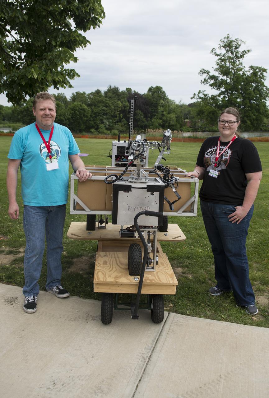Jim Rothrock, left, and Carrie Johnson, right, of the Wunderkammer Laboratory team pose for a picture with their robot after attempting the level one competition during the 2014 NASA Centennial Challenges Sample Return Robot Challenge, Wednesday, June 11, 2014, at the Worcester Polytechnic Institute (WPI) in Worcester, Mass.   Eighteen teams are competing for a $1.5 million NASA prize purse. Teams will be required to demonstrate autonomous robots that can locate and collect samples from a wide and varied terrain, operating without human control. The objective of this NASA-WPI Centennial Challenge is to encourage innovations in autonomous navigation and robotics technologies. Innovations stemming from the challenge may improve NASA's capability to explore a variety of destinations in space, as well as enhance the nation's robotic technology for use in industries and applications on Earth. Photo Credit: (NASA/Joel Kowsky)