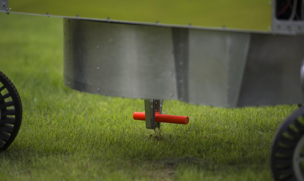 The team Survey robot retrieves a sample during a demonstration of the level two challenge at the 2014 NASA Centennial Challenges Sample Return Robot Challenge, Thursday, June 12, 2014, at the Worcester Polytechnic Institute (WPI) in Worcester, Mass.   Eighteen teams are competing for a $1.5 million NASA prize purse. Teams will be required to demonstrate autonomous robots that can locate and collect samples from a wide and varied terrain, operating without human control. The objective of this NASA-WPI Centennial Challenge is to encourage innovations in autonomous navigation and robotics technologies. Innovations stemming from the challenge may improve NASA's capability to explore a variety of destinations in space, as well as enhance the nation's robotic technology for use in industries and applications on Earth. Photo Credit: (NASA/Joel Kowsky)
