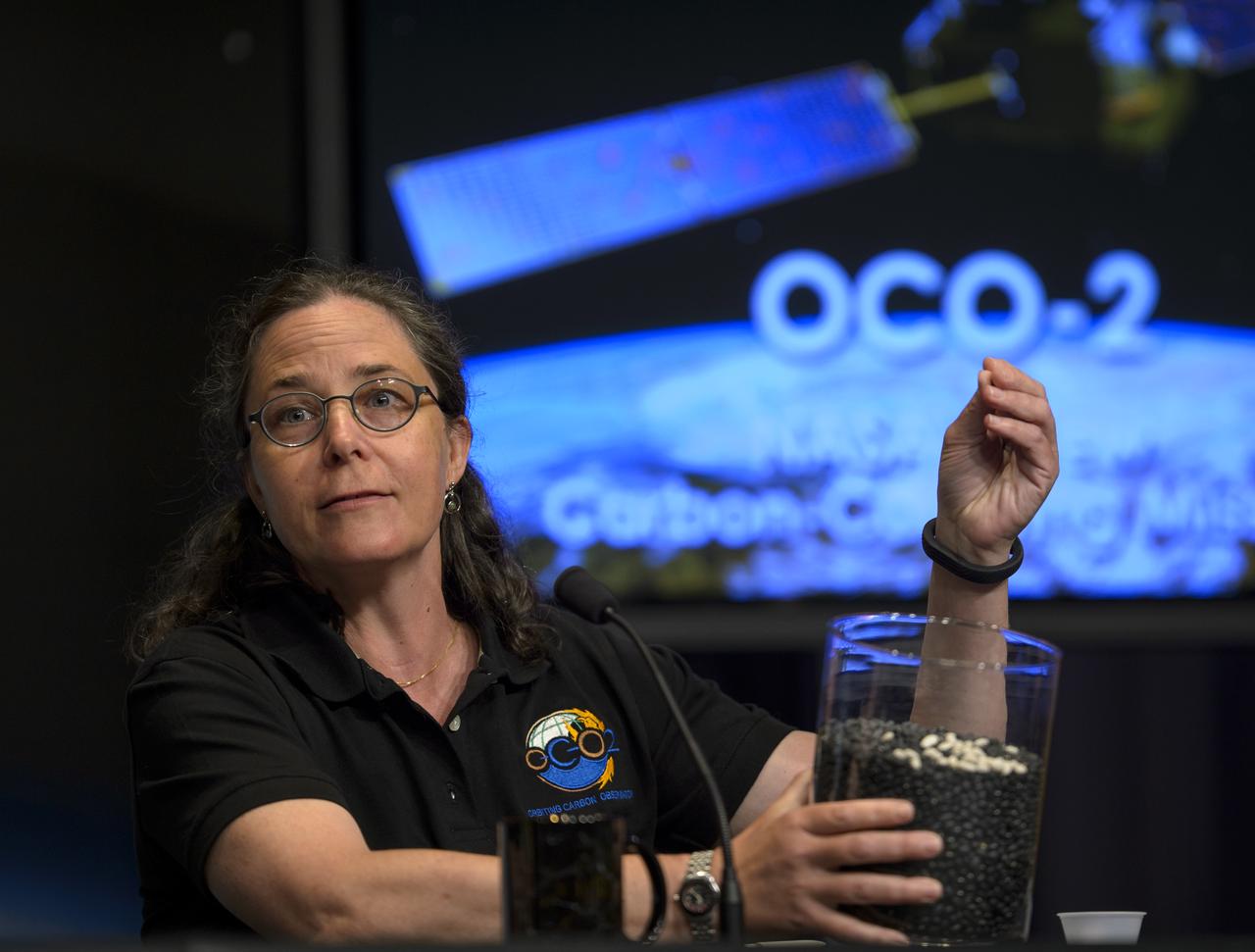 Annmarie Eldering, OCO-2 deputy project scientist with NASA’s Jet Propulsion Laboratory (JPL) in Pasadena, California, demonstrates with a few white beans in a container of black beans the small differences in carbon dioxide in the atmosphere that the Orbiting Carbon Observatory-2 (OCO-2) will be able to measure, during a press briefing, Thursday, June 12, 2014, at NASA Headquarters in Washington. OCO-2, NASA’s first spacecraft dedicated to studying carbon dioxide, is set for a July 1, 2014, launch from Vandenberg Air Force Base in California. Its mission is to measure the global distribution of carbon dioxide, the leading human-produced greenhouse gas driving changes in Earth’s climate.  Photo Credit: (NASA/Bill Ingalls)