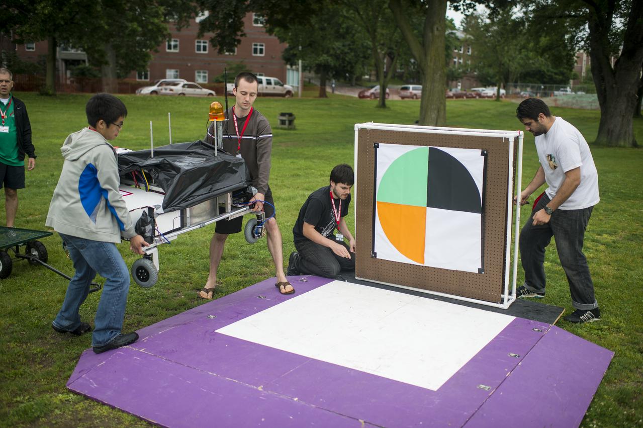 The University of California Santa Cruz Rover Team prepares their rover for the rerun of the level one challenge during the 2014 NASA Centennial Challenges Sample Return Robot Challenge, Saturday, June 14, 2014, at the Worcester Polytechnic Institute (WPI) in Worcester, Mass.   Eighteen teams are competing for a $1.5 million NASA prize purse. Teams will be required to demonstrate autonomous robots that can locate and collect samples from a wide and varied terrain, operating without human control. The objective of this NASA-WPI Centennial Challenge is to encourage innovations in autonomous navigation and robotics technologies. Innovations stemming from the challenge may improve NASA's capability to explore a variety of destinations in space, as well as enhance the nation's robotic technology for use in industries and applications on Earth. Photo Credit: (NASA/Joel Kowsky)