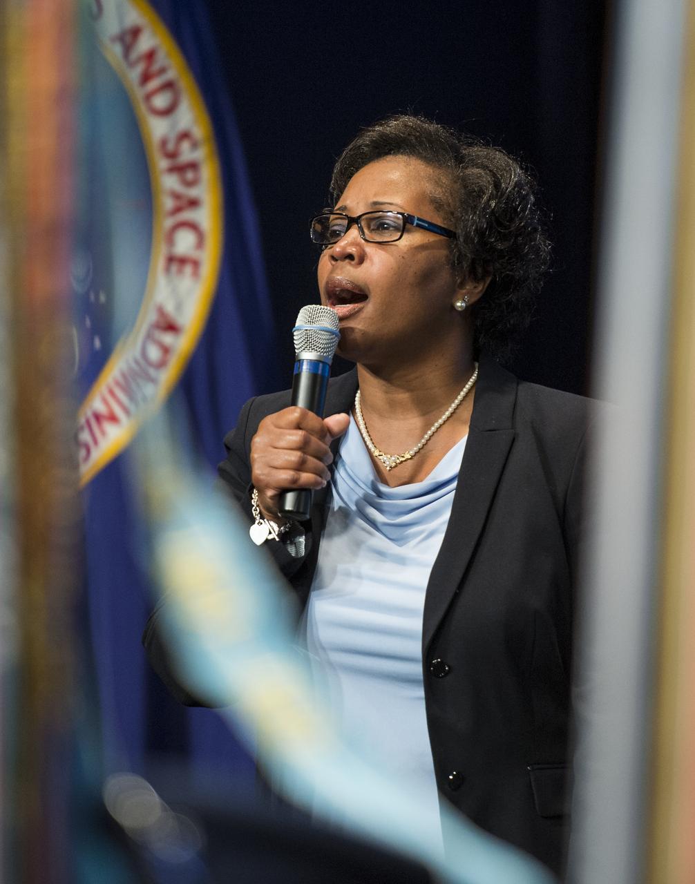 Omega Jones sings the national anthem as a color guard from the at an event celebrating the 50th Anniversary of the Civil Rights Act of 1964 on Monday, June 23, 2014 in the James E. Webb Auditorium at NASA Headquarters in Washington, DC.  The event highlighted the influence of the Civil Rights Act on NASA. Photo Credit: (NASA/Joel Kowsky)