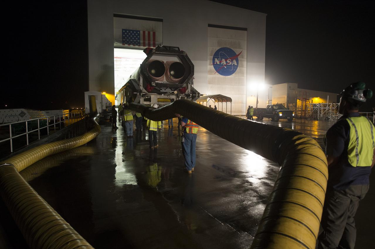 The Orbital Sciences Corporation Antares rocket, with the Cygnus spacecraft onboard, is rolled out of the Horizontal Integration Facility (HIF) to begin the approximately half-mile journey to launch Pad-0A, Thursday, July 10, 2014, at NASA's Wallops Flight Facility in Virginia. The Antares will launch with the Cygnus spacecraft filled with over 3,000 pounds of supplies for the International Space Station, including science experiments, experiment hardware, spare parts, and crew provisions. The Orbital-2 mission is Orbital Sciences' second contracted cargo delivery flight to the space station for NASA. Photo Credit: (NASA/Aubrey Gemignani)
