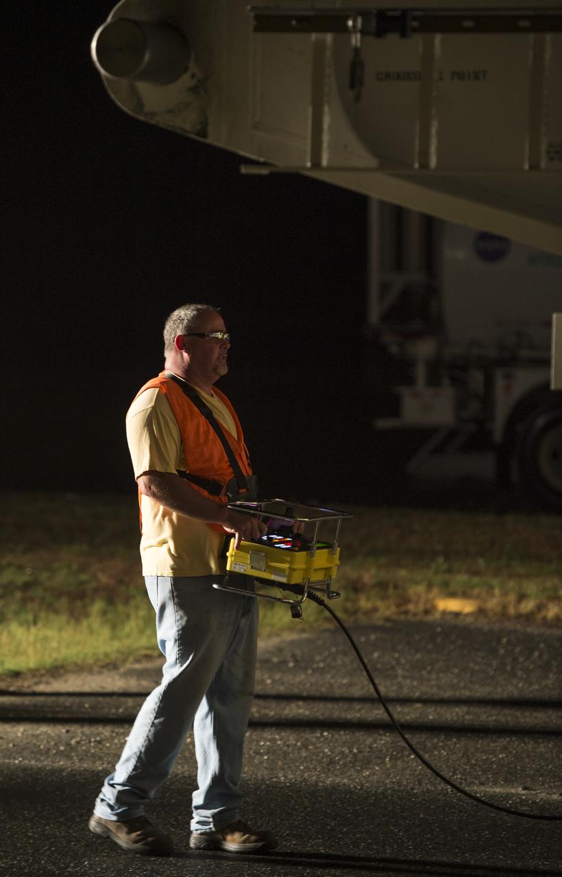 Chris McDonald with Orbital Sciences, drives the Antares rocket, with the Cygnus spacecraft onboard, from the Horizontal Integration Facility (HIF) to launch Pad-0A, Thursday, July 10, 2014, at NASA's Wallops Flight Facility in Virginia. The Antares will launch with the Cygnus spacecraft filled with over 3,000 pounds of supplies for the International Space Station, including science experiments, experiment hardware, spare parts, and crew provisions. The Orbital-2 mission is Orbital Sciences' second contracted cargo delivery flight to the space station for NASA. Photo Credit: (NASA/Bill Ingalls)