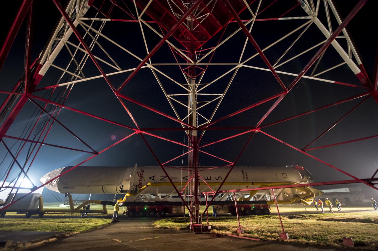 The Orbital Sciences Corporation Antares rocket, with the Cygnus spacecraft onboard, rolls from the Horizontal Integration Facility (HIF) to launch Pad-0A, Thursday, July 10, 2014, at NASA's Wallops Flight Facility in Virginia. The Antares will launch with the Cygnus spacecraft filled with over 3,000 pounds of supplies for the International Space Station, including science experiments, experiment hardware, spare parts, and crew provisions. The Orbital-2 mission is Orbital Sciences' second contracted cargo delivery flight to the space station for NASA. Photo Credit: (NASA/Bill Ingalls)