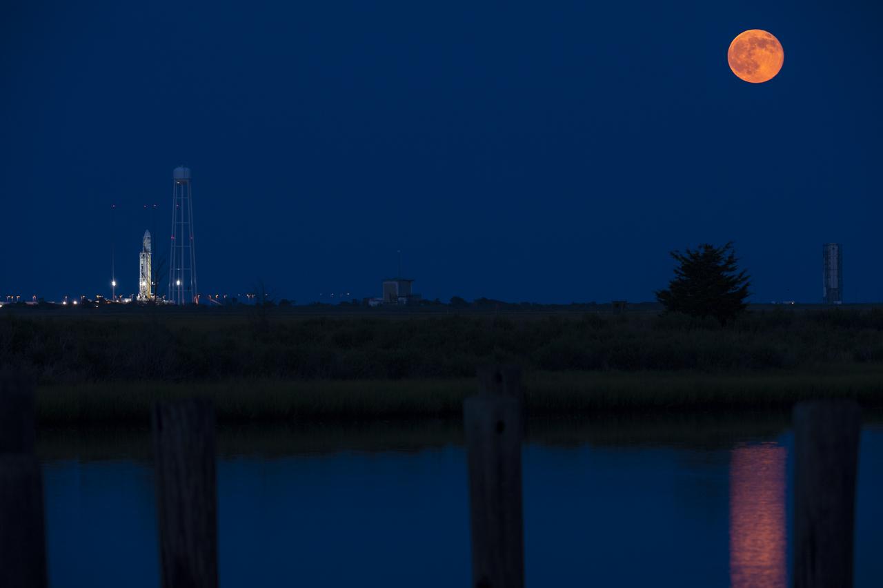 The full Moon rises in the sky to the right of the Orbital Sciences Corporation Antares rocket, with the Cygnus spacecraft onboard, Saturday, July 12, 2014, launch Pad-0A, NASA's Wallops Flight Facility in Virginia. The Antares is scheduled to launch Sunday, July 13, 2014 with the Cygnus spacecraft filled with over 3,000 pounds of supplies for the International Space Station, including science experiments, experiment hardware, spare parts, and crew provisions. The Orbital-2 mission is Orbital Sciences' second contracted cargo delivery flight to the space station for NASA. Photo Credit: (NASA/Aubrey Gemignani)