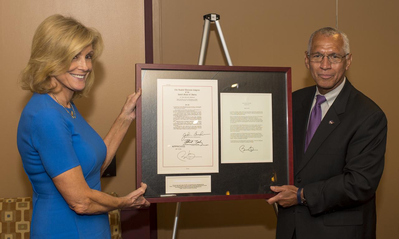 NASA Administrator Charles Bolden, right, presents Carol Armstrong, widow of Apollo 11 commander, Neil Armstrong, with the signed bill that renamed the Hugh L. Dryden Flight Research Center as the Neil A. Armstrong Flight Research Center, Tuesday, July 22, 2014 at NASA Headquarters in Washington. Photo Credit: (NASA/Joel Kowsky)