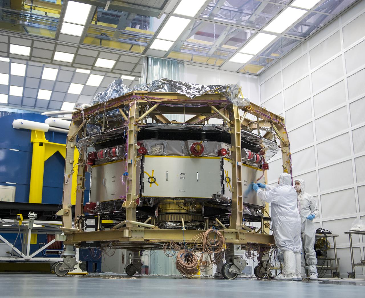 Engineers work on one of four Magnetospheric Multiscale (MMS) spacecraft in a cleanroom at the Naval Research Lab, Monday, August 4, 2014, in Washington. The Magnetospheric Multiscale, or MMS, mission will study the mystery of how magnetic fields around Earth connect and disconnect, explosively releasing energy via a process known as magnetic reconnection. The four identical spacecraft are scheduled to launch in 2015 from Cape Canaveral and will orbit around Earth in varying formations through the dynamic magnetic system surrounding our planet to provide the first three-dimensional views of the magnetic reconnection process. The goal of the STP Program is to understand the fundamental physical processes of the space environment from the sun to Earth, other planets, and the extremes of the solar system boundary. Photo Credit: (NASA/Bill Ingalls)