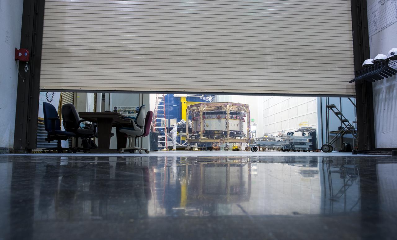 One of four Magnetospheric Multiscale (MMS) spacecraft, in the background, is seen in a cleanroom at the Naval Research Lab’s, Naval Center for Space Technology, Monday, August 4, 2014, in Washington. The Magnetospheric Multiscale, or MMS, mission will study the mystery of how magnetic fields around Earth connect and disconnect, explosively releasing energy via a process known as magnetic reconnection. The four identical spacecraft are scheduled to launch in 2015 from Cape Canaveral and will orbit around Earth in varying formations through the dynamic magnetic system surrounding our planet to provide the first three-dimensional views of the magnetic reconnection process. The goal of the STP Program is to understand the fundamental physical processes of the space environment from the sun to Earth, other planets, and the extremes of the solar system boundary. Photo Credit: (NASA/Bill Ingalls)
