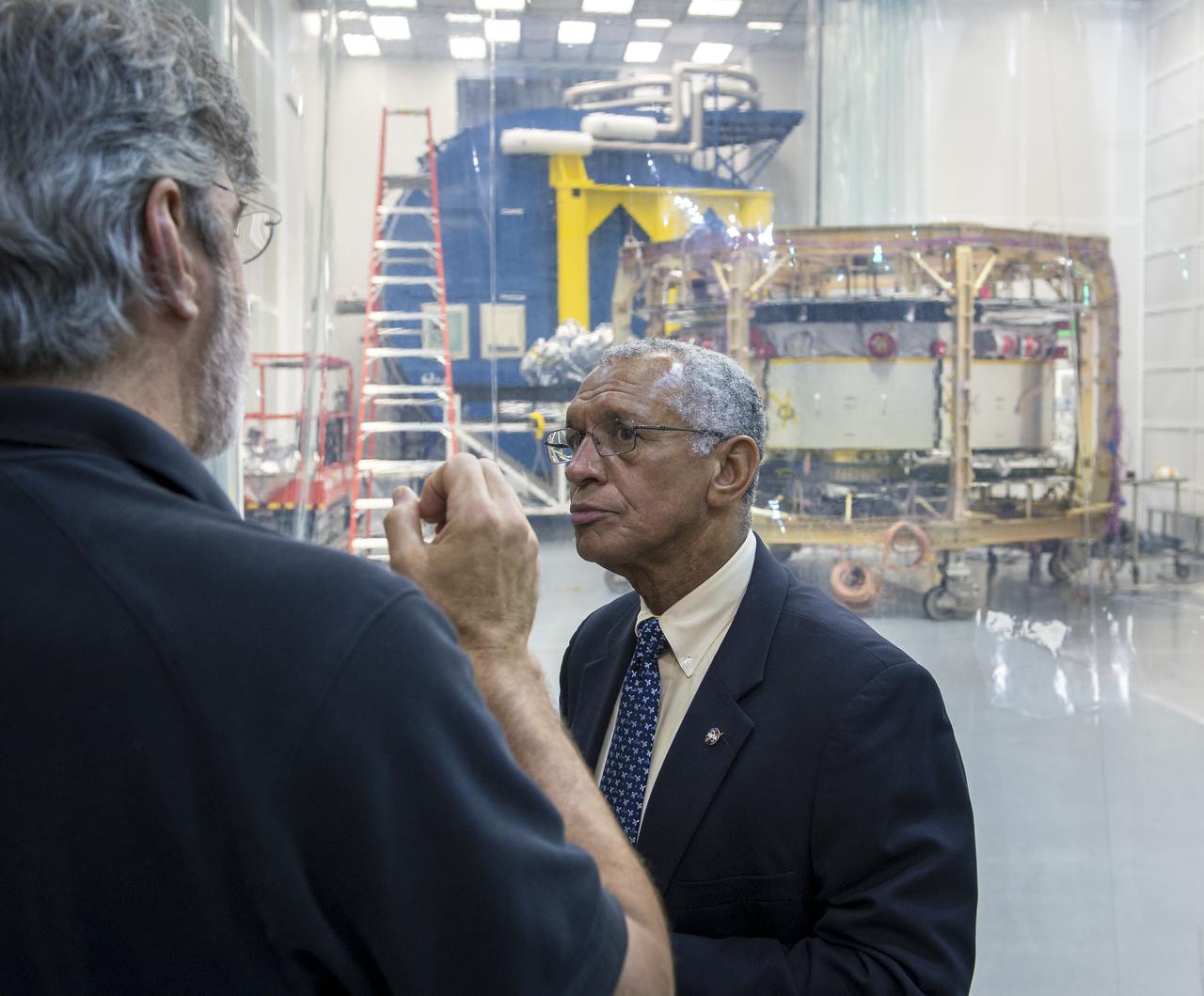 NASA Administrator Charles Bolden listens to Magnetospheric Multiscale (MMS) Mission Project Manager Craig Tooley talk about the MMS mission outside of a Naval Research Laboratory cleanroom where one of four Magnetospheric Multiscale (MMS) spacecraft is currently undergoing testing, Monday, August 4, 2014, in Washington. The Magnetospheric Multiscale, or MMS, mission will study the mystery of how magnetic fields around Earth connect and disconnect, explosively releasing energy via a process known as magnetic reconnection. The four identical spacecraft are scheduled to launch in 2015 from Cape Canaveral and will orbit around Earth in varying formations through the dynamic magnetic system surrounding our planet to provide the first three-dimensional views of the magnetic reconnection process. The goal of the STP Program is to understand the fundamental physical processes of the space environment from the sun to Earth, other planets, and the extremes of the solar system boundary. Photo Credit: (NASA/Bill Ingalls)