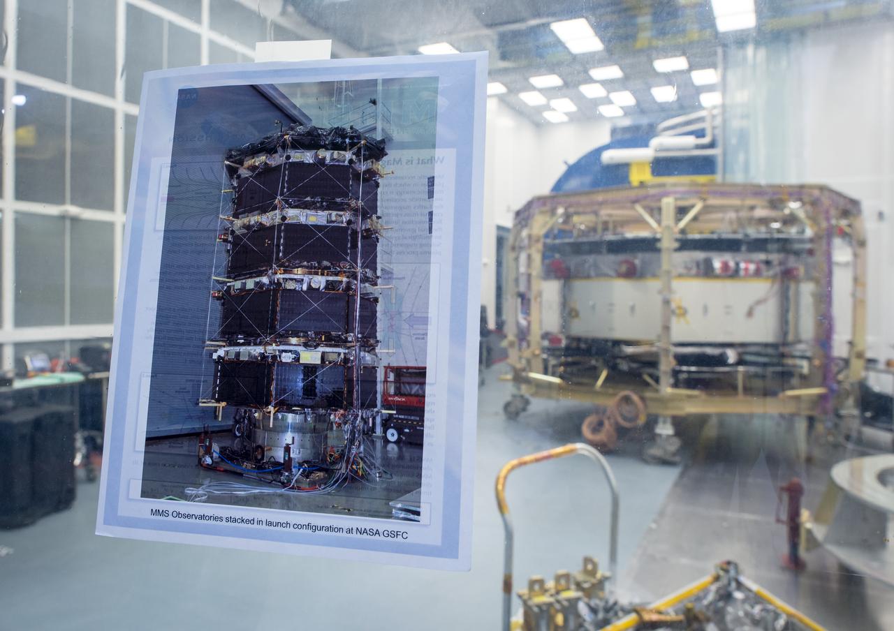 A photograph showing what all four Magnetospheric Multiscale (MMS) spacecraft look like when stacked is seen taped to the window of a Naval Research Laboratory cleanroom where one of the four spacecraft is undergoing testing, Monday, August 4, 2014, in Washington. The Magnetospheric Multiscale, or MMS, mission will study the mystery of how magnetic fields around Earth connect and disconnect, explosively releasing energy via a process known as magnetic reconnection. The four identical spacecraft are scheduled to launch in 2015 from Cape Canaveral and will orbit around Earth in varying formations through the dynamic magnetic system surrounding our planet to provide the first three-dimensional views of the magnetic reconnection process. The goal of the STP Program is to understand the fundamental physical processes of the space environment from the sun to Earth, other planets, and the extremes of the solar system boundary. Photo Credit: (NASA/Bill Ingalls)