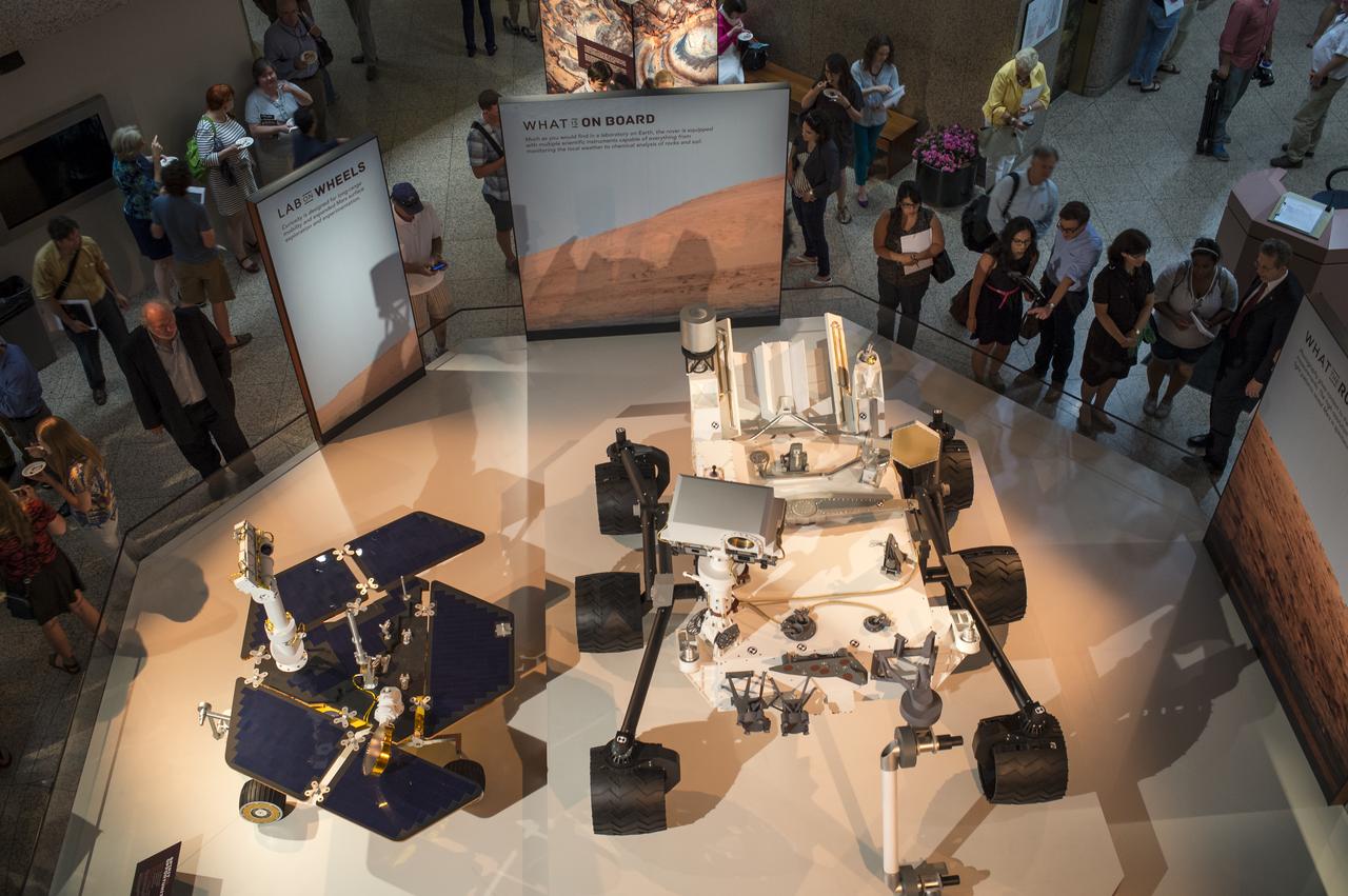 Guest attending the National Geographic “Mars Up Close” panel discussion, look at full scale models of the Spirit/Opportunity, left, and Curiosity, Mars rovers, Tuesday, August 5, 2014, at the National Geographic Society headquarters in Washington. Guest listened to a panel of distinguished space scientists and Mars experts involved in current Mars exploration that shared what we’ve learned from Curiosity and the other Mars rovers. Photo Credit: (NASA/Bill Ingalls)