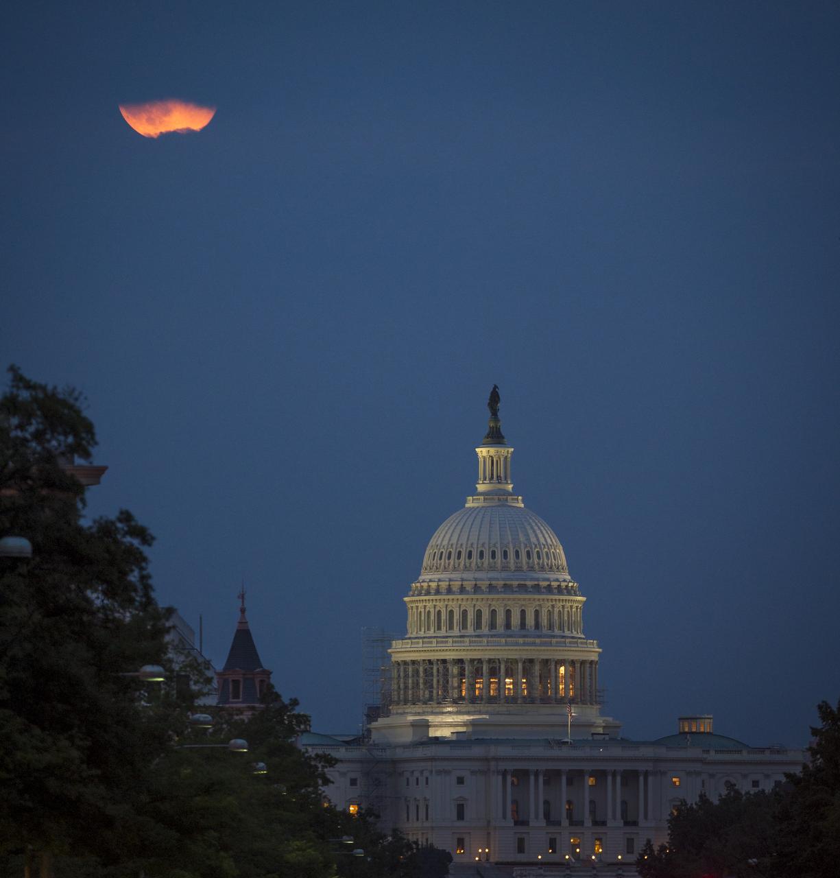 A perigee full moon or supermoon is seen behind clouds over the United States Capitol, Sunday, August 10, 2014, in Washington. A supermoon occurs when the moon’s orbit is closest (perigee) to Earth at the same time it is full. Photo Credit: (NASA/Bill Ingalls)