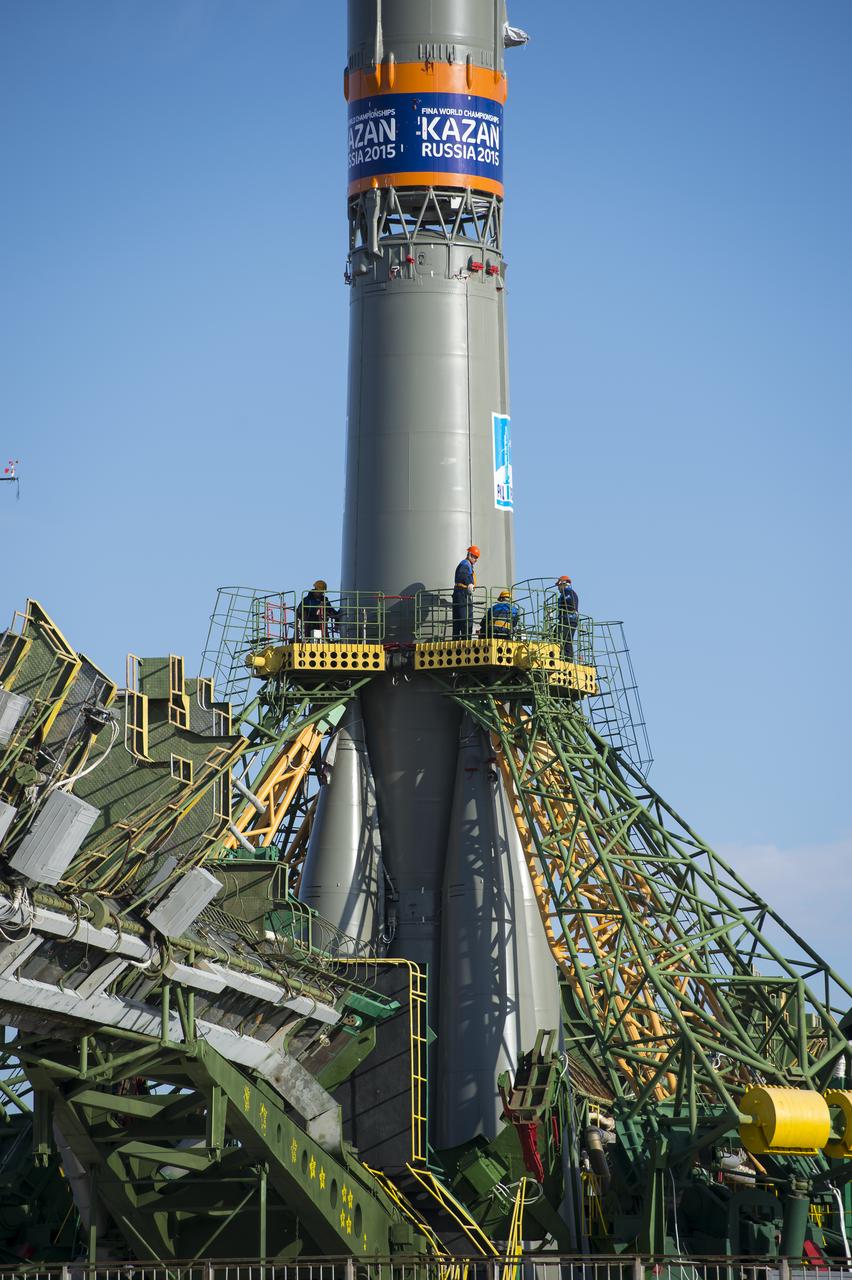 Workers prepare to raise the gantry arms to secure the Soyuz TMA-14M spacecraft at the launch pad Sept. 23, 2014 at the Baikonur Cosmodrome in Kazakhstan. Launch of the Soyuz rocket is scheduled for Sept. 26 and will carry Expedition 41 Soyuz Commander Alexander Samokutyaev of the Russian Federal Space Agency (Roscosmos), Flight Engineer Barry Wilmore of NASA, and Flight Engineer Elena Serova of Roscosmos into orbit to begin their five and a half month mission on the International Space Station. The rocket is adorned with the logo of the 2015 FINA World Aquatics Championships, which will be held in Kazan, Russia. Photo Credit: (NASA/Aubrey Gemignani)