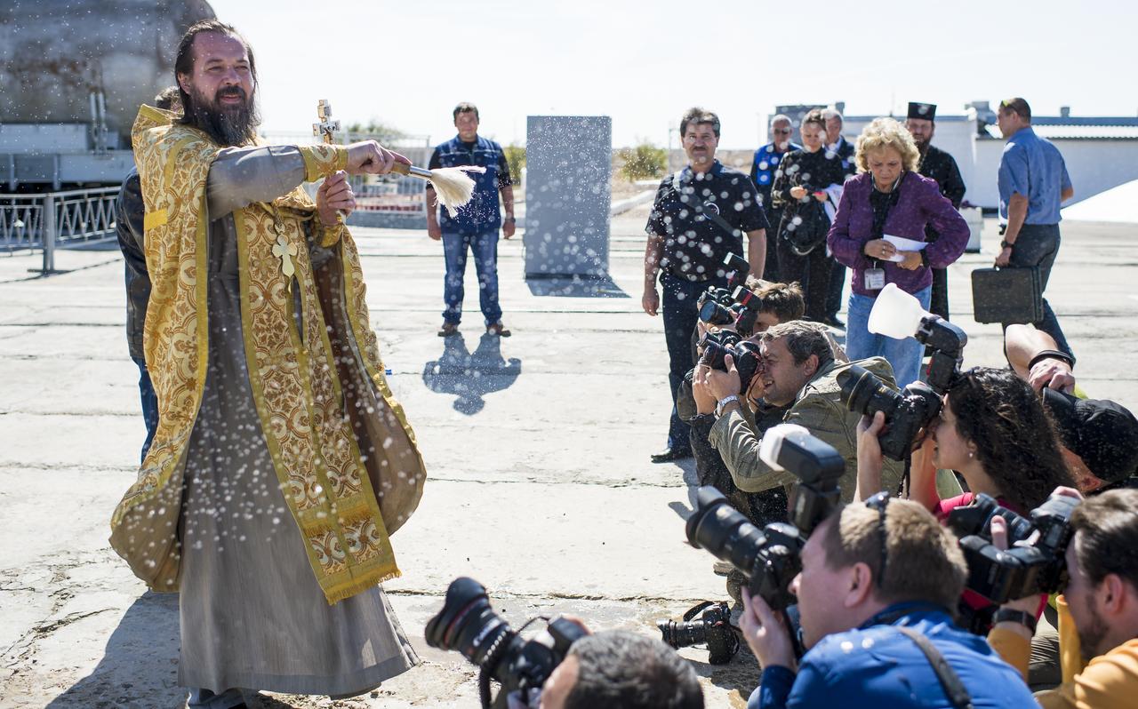 An Orthodox priest blesses members of the media at the Baikonur Cosmodrome launch pad on Wednesday, September 24, 2014 in Kazakhstan.  Launch of the Soyuz rocket is scheduled for September 26 and will send Expedition 41 Soyuz Commander Alexander Samokutyaev of the Russian Federal Space Agency (Roscosmos), Flight Engineer Elena Serova of Roscosmos, and Flight Engineer Barry Wilmore of NASA on a five and a half month mission aboard the International Space Station.  Serova will become the fourth Russian woman to fly in space and the first Russian woman to live and work on the station.  Photo Credit: (NASA/Joel Kowsky)